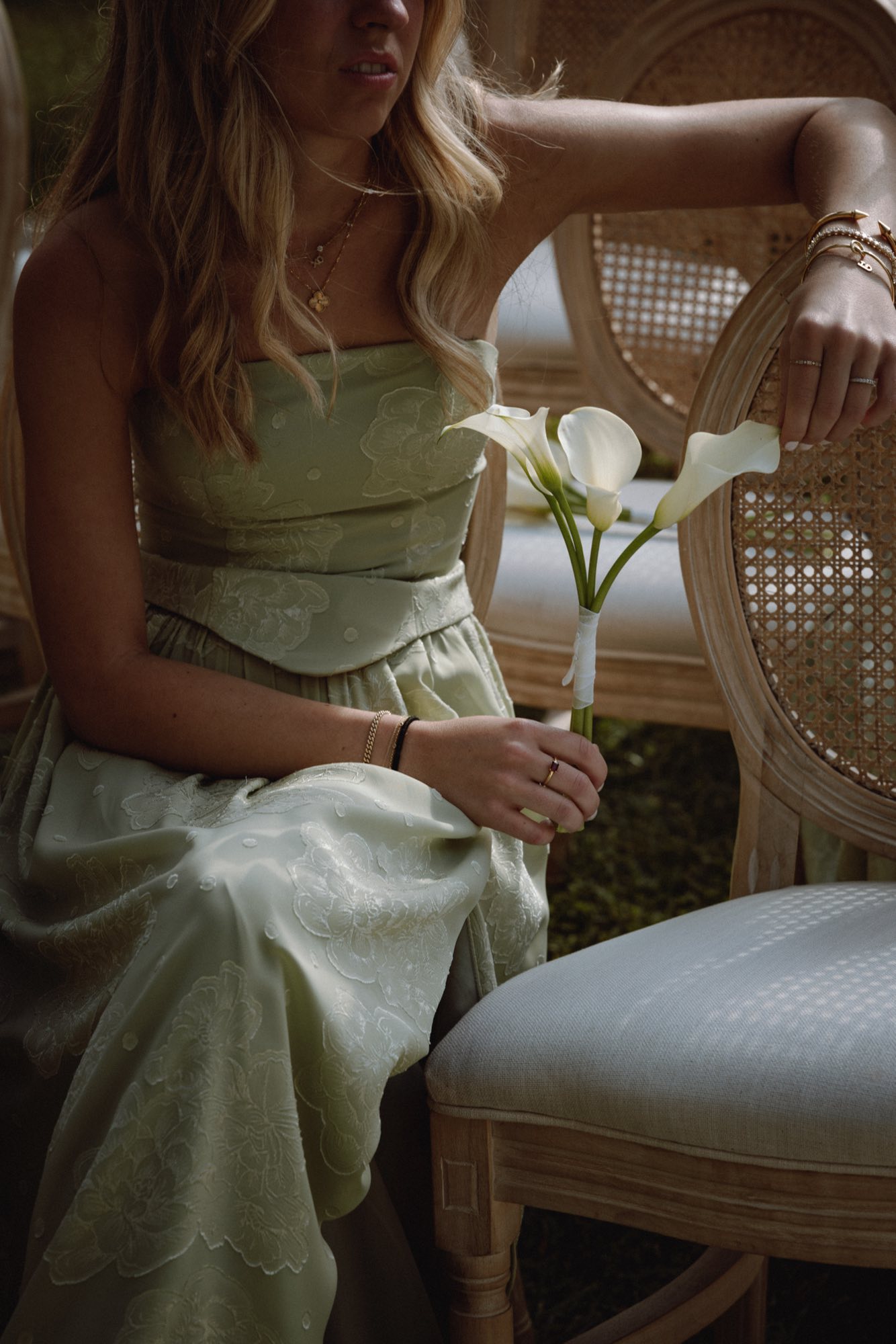 Soft focus detail of floral wedding dress with calla lilies and anthuriums
