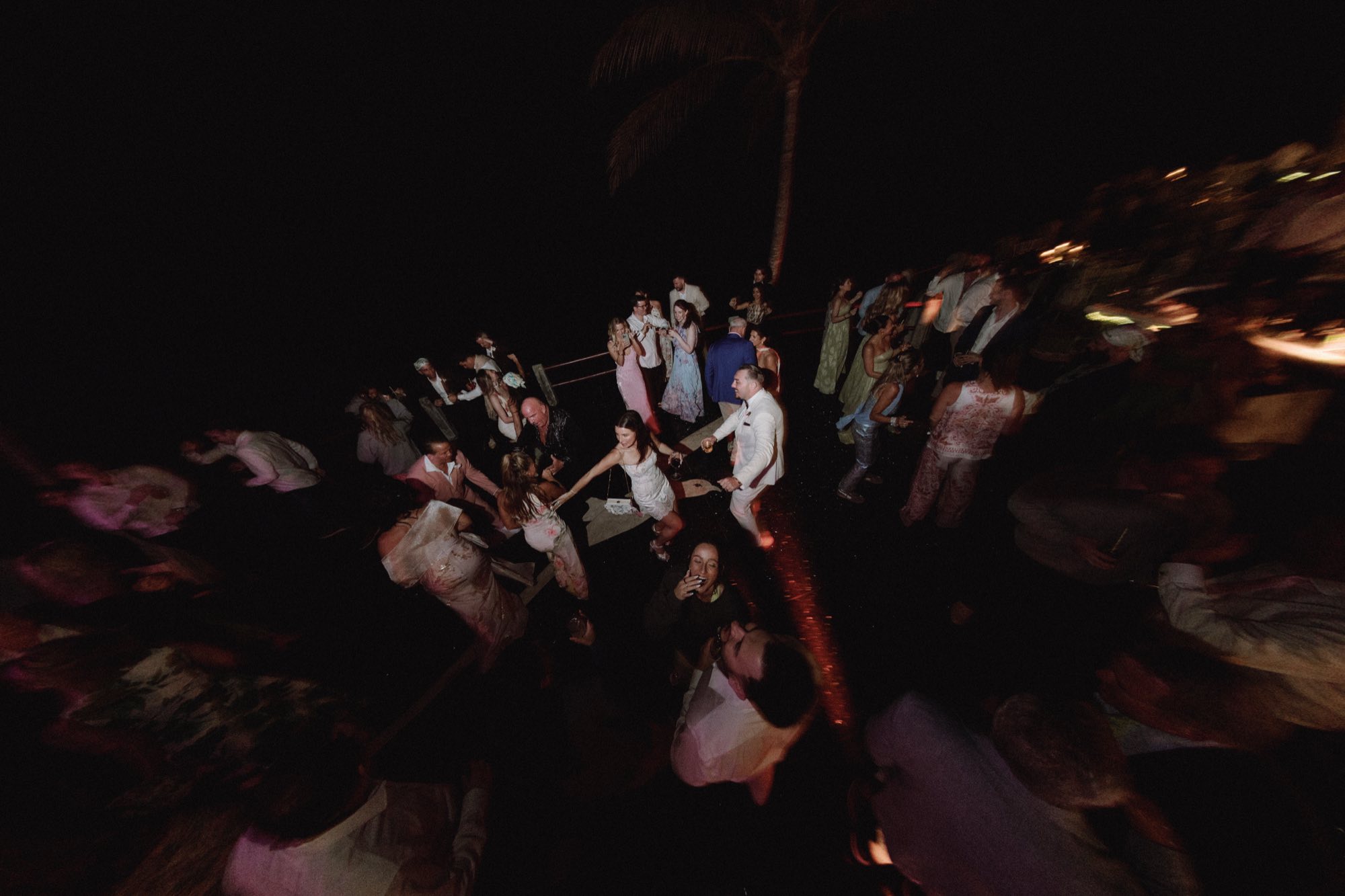 Cinematic flash photograph of energetic dance floor at wedding reception