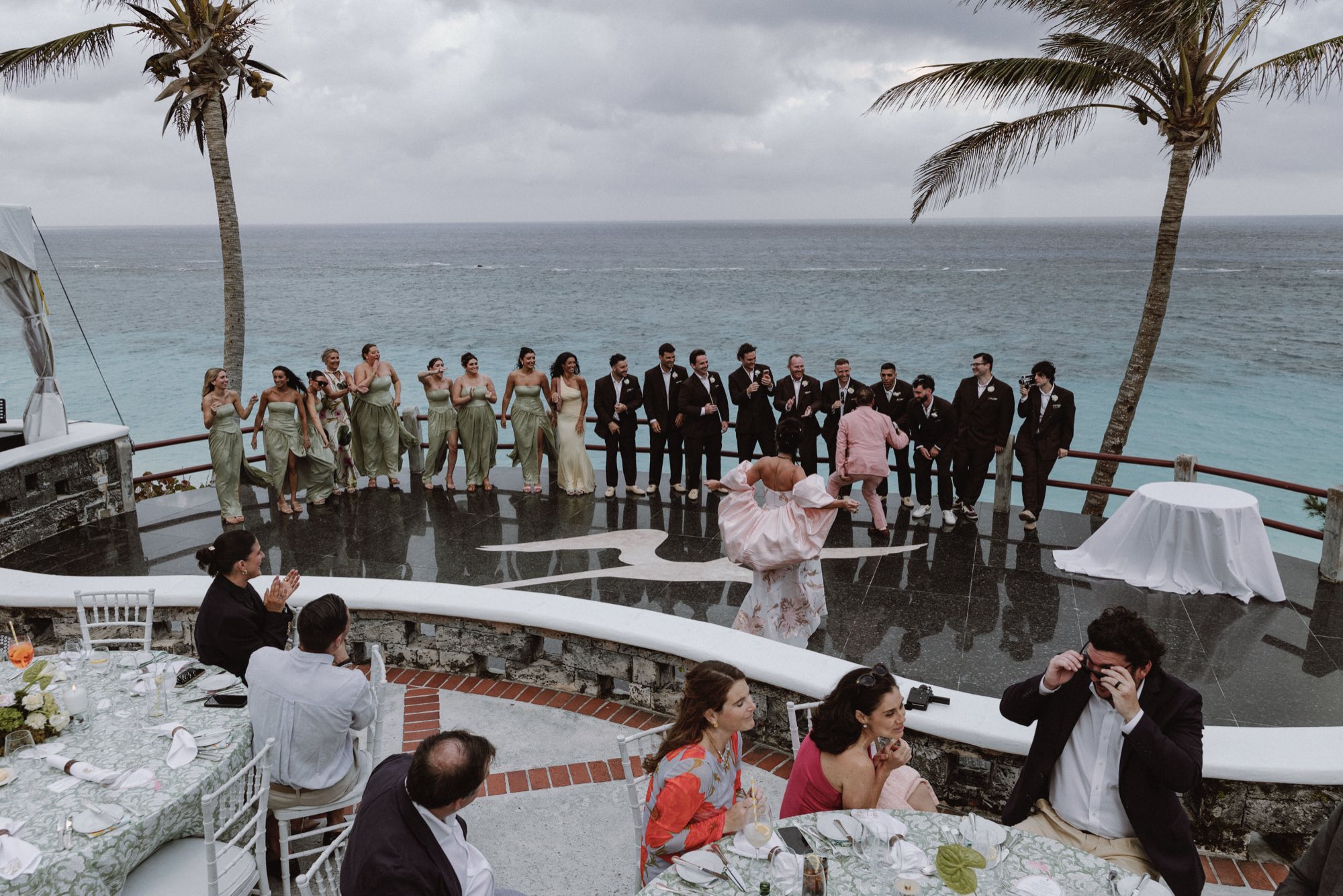 Spontaneous guest performance overlooking the ocean at wedding reception
