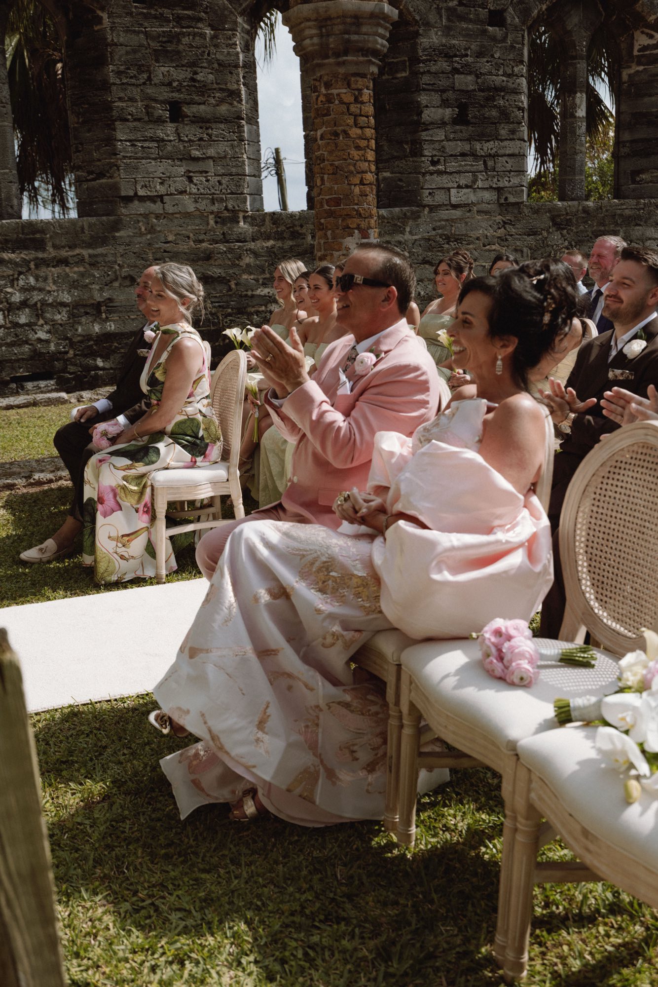 Wedding guests applauding in sunlight during outdoor Bermuda ceremony