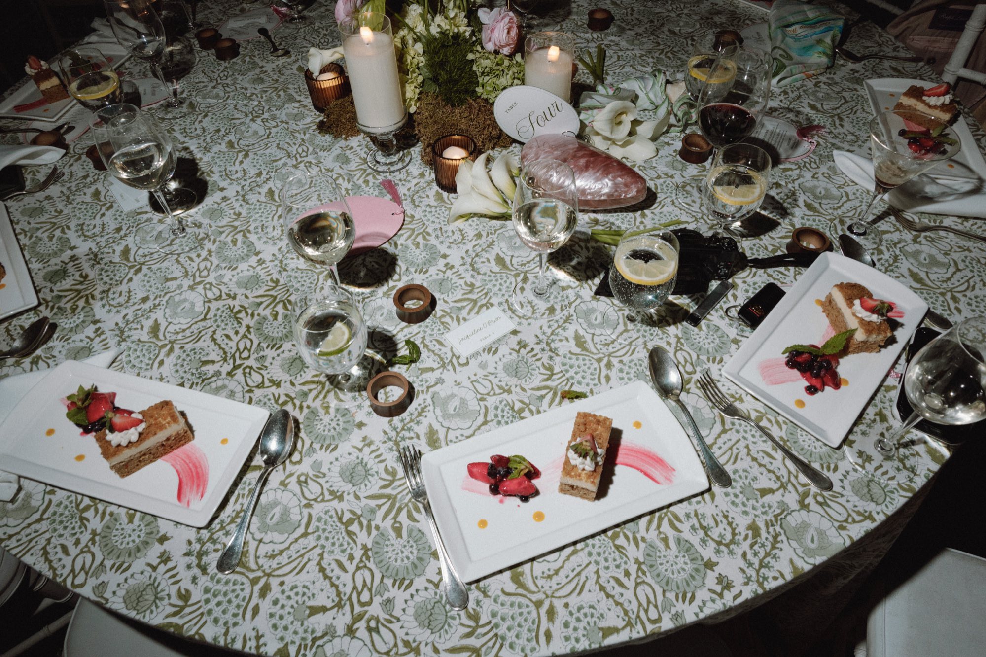 Elegant table setting with dessert and floral arrangement at wedding reception