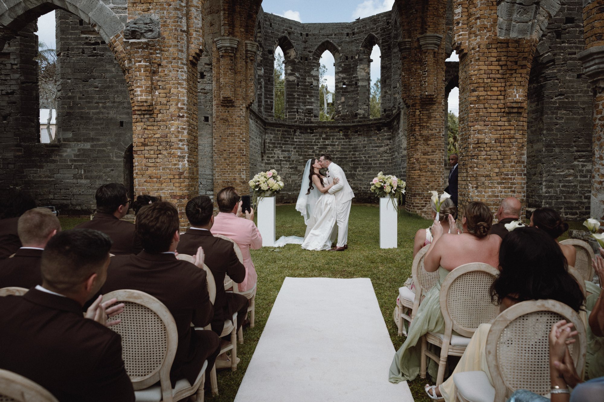 First kiss between bride and groom at historic unfinished church ruins ceremony