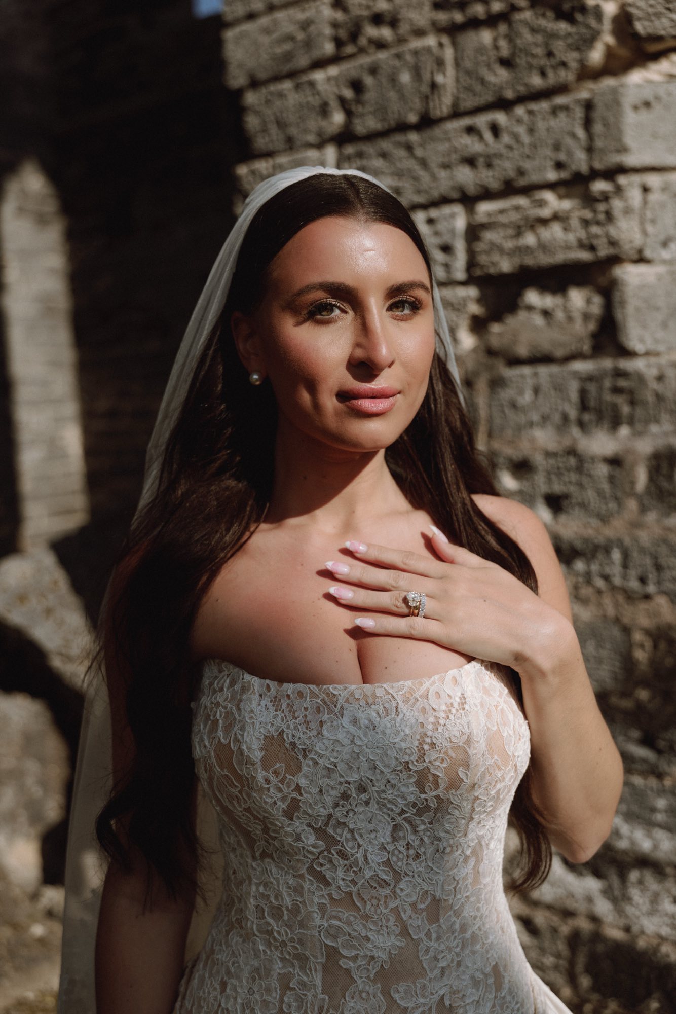 Soft sunlight portrait of bride hand on chest at historic stone ruins Bermuda