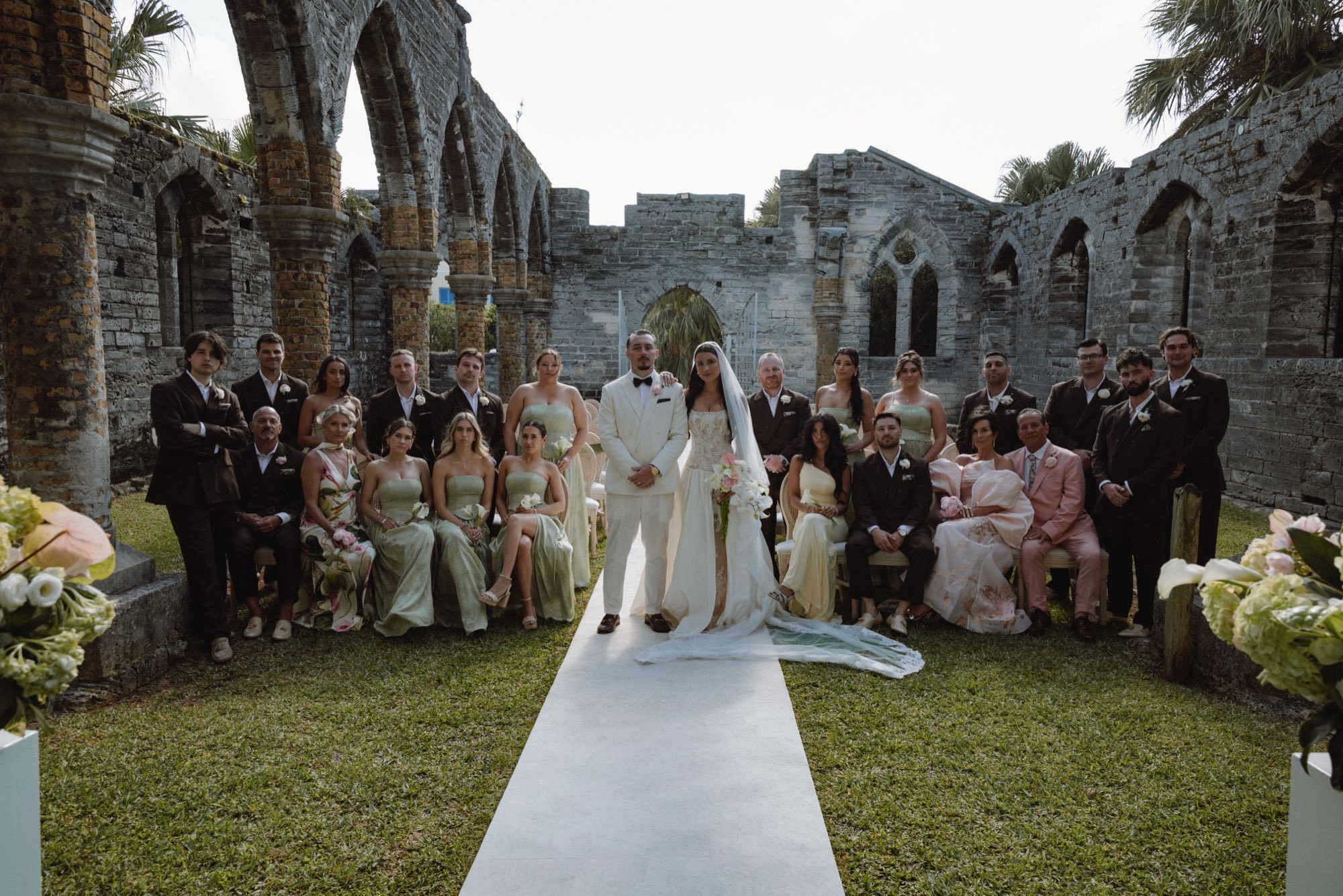 Editorial wedding party portrait with white aisle runner at historic Bermuda church ruins