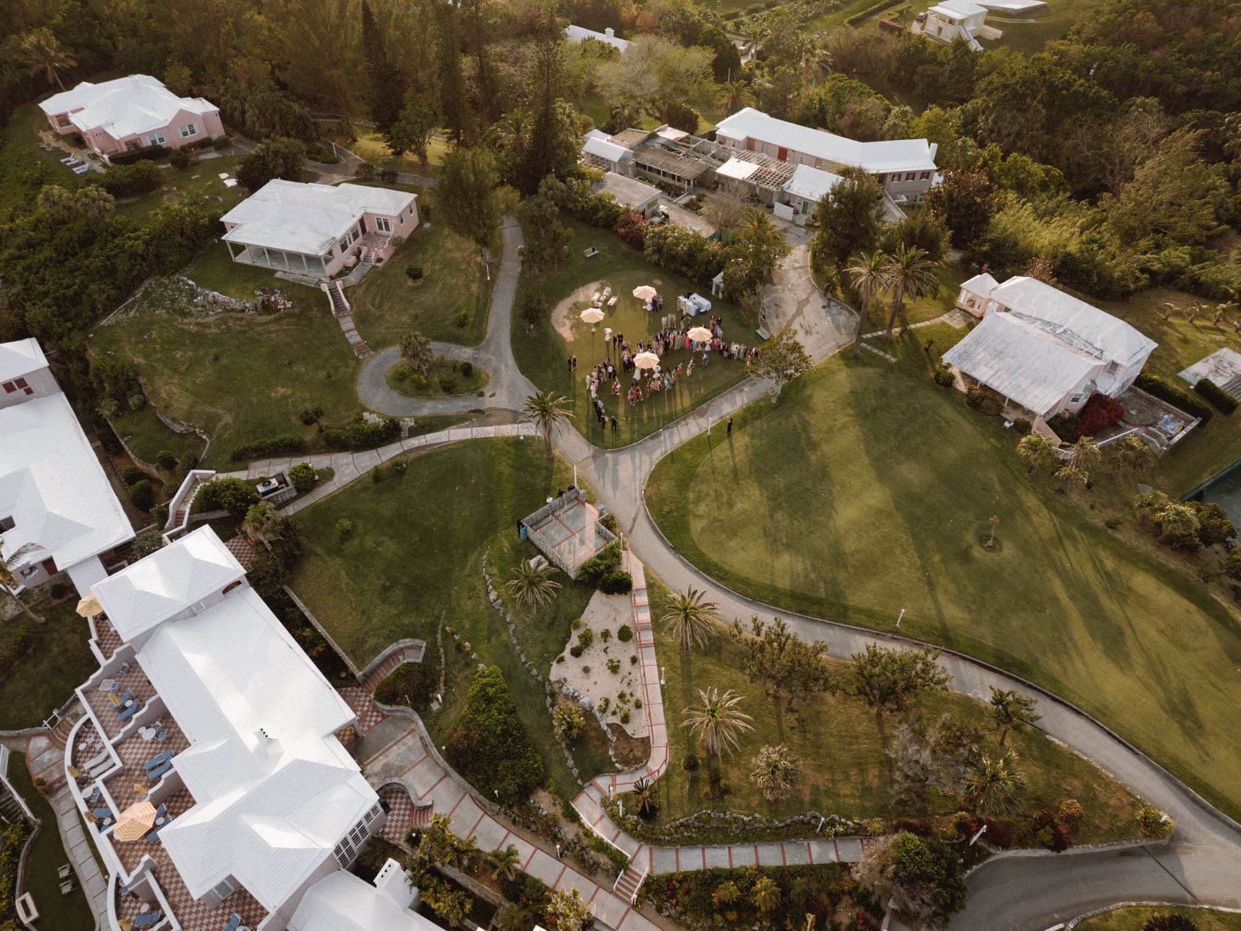 Aerial view of Bermuda destination wedding ceremony setup at oceanside resort with white roofed villas