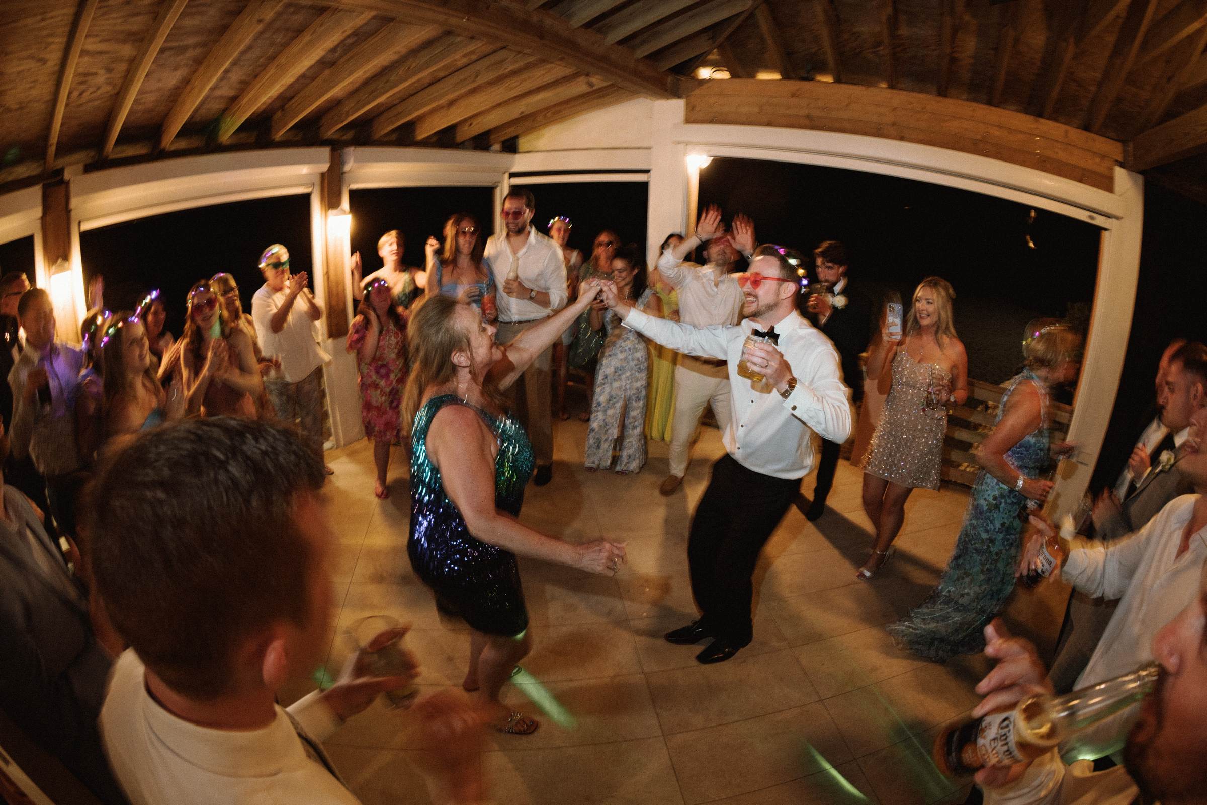 Wide dance floor energy with hands raised at Bermuda wedding reception