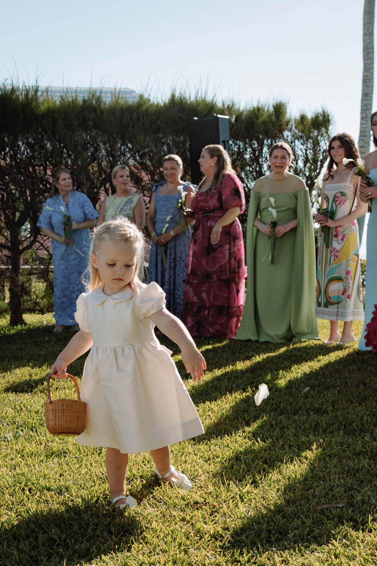 Flower girl carrying a basket down the aisle at an oceanfront Bermuda wedding ceremony