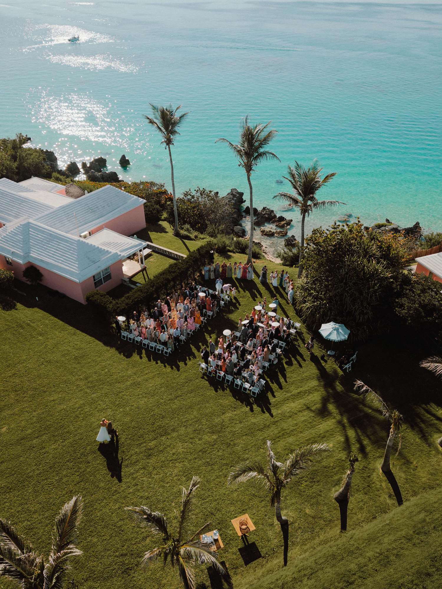 Aerial view of an oceanfront ceremony beside a pink Bermuda resort