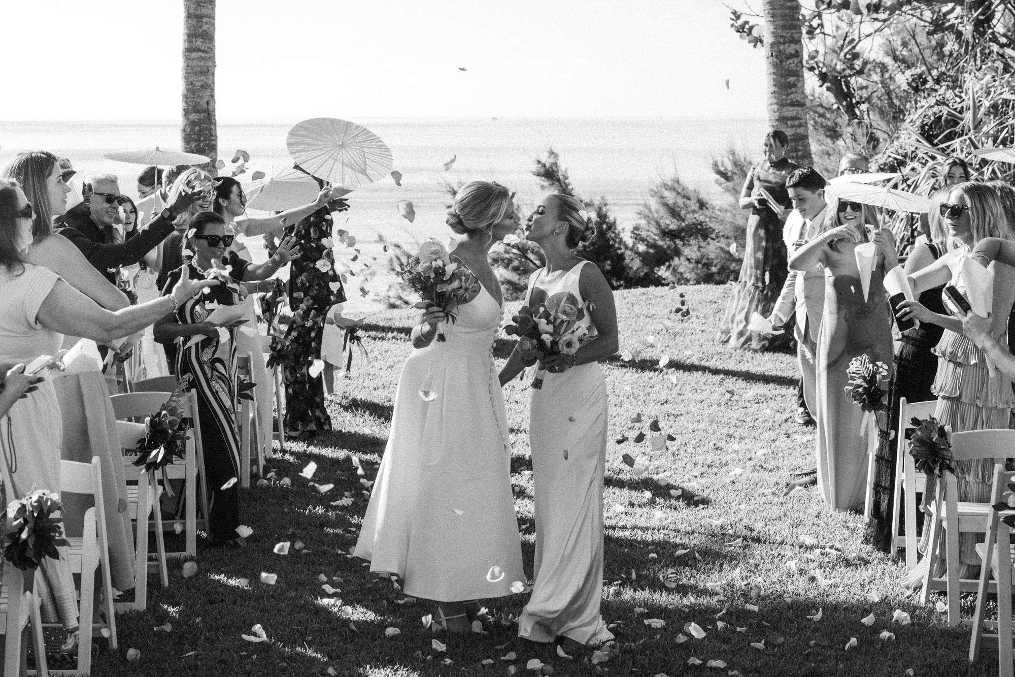 Black and white recessional through a petal toss and paper parasols at a Bermuda wedding
