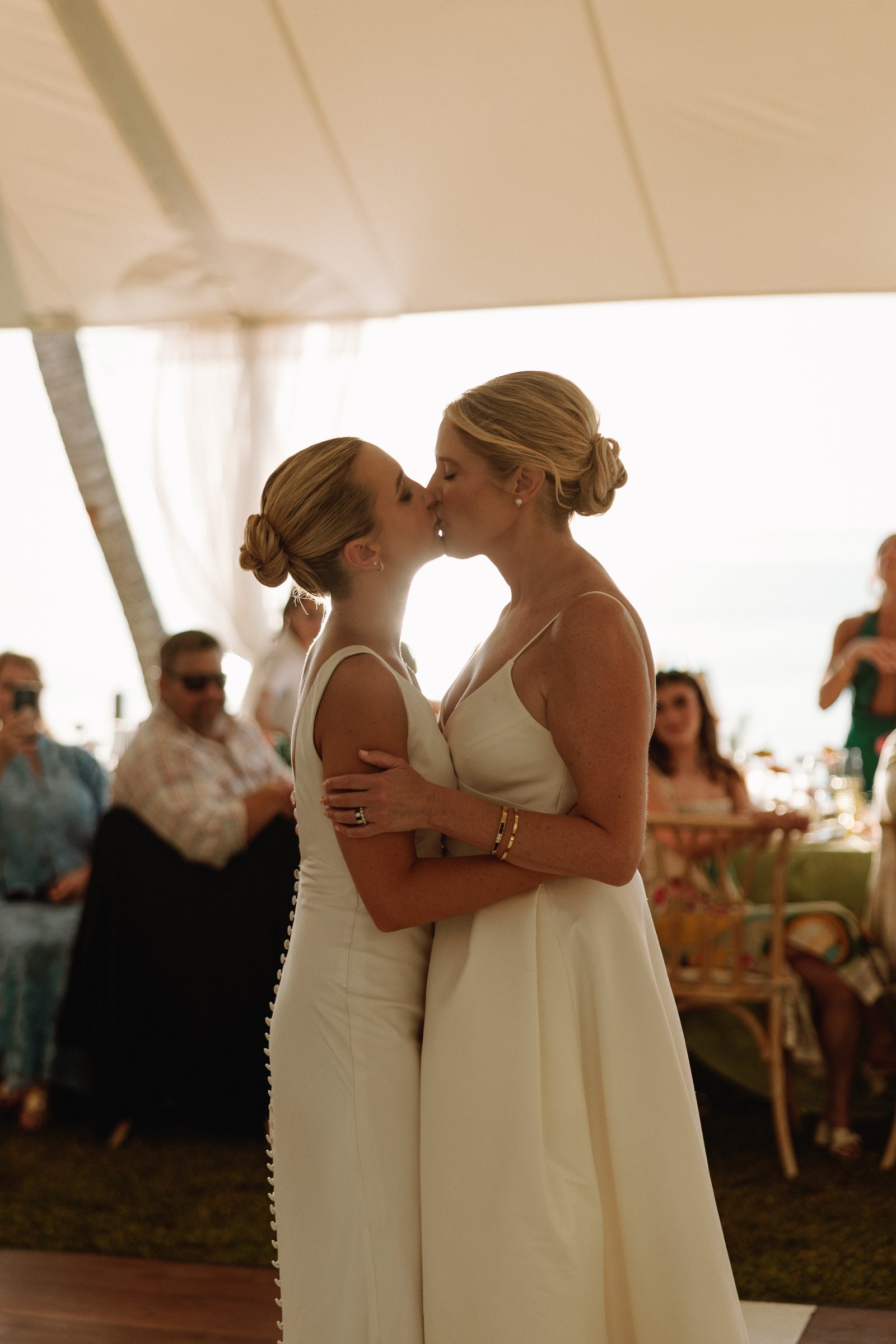 Two brides kissing during their Bermuda wedding reception