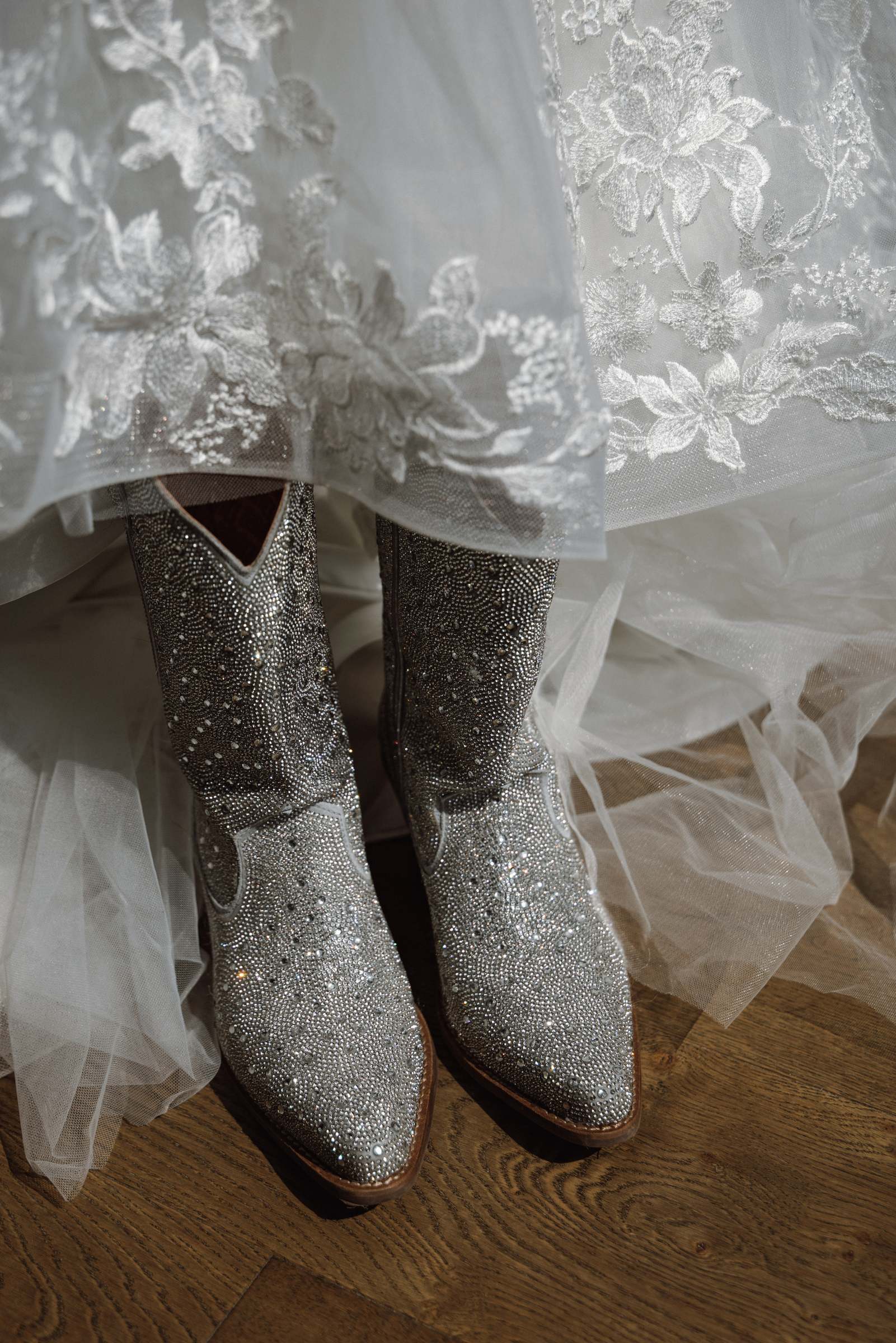 Glitter cowboy boots peeking out from under a lace wedding dress