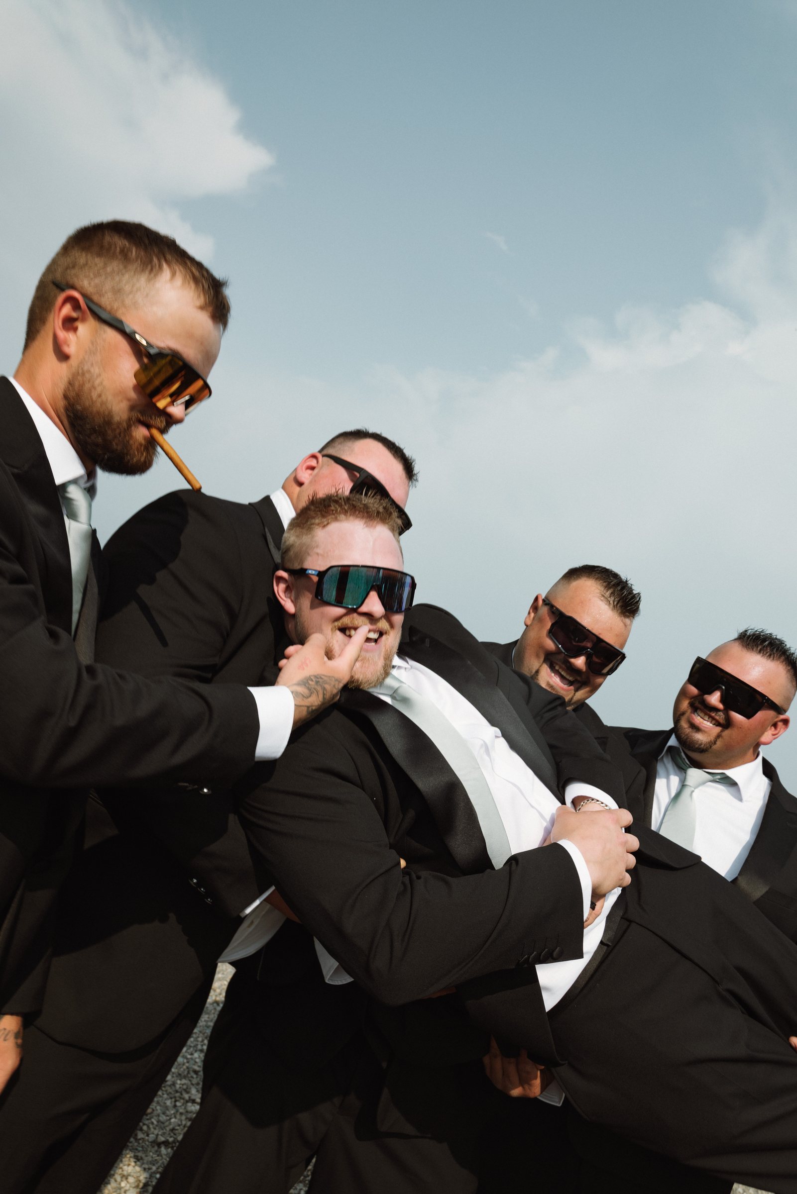 Groomsmen goofing around with a cigar after the ceremony