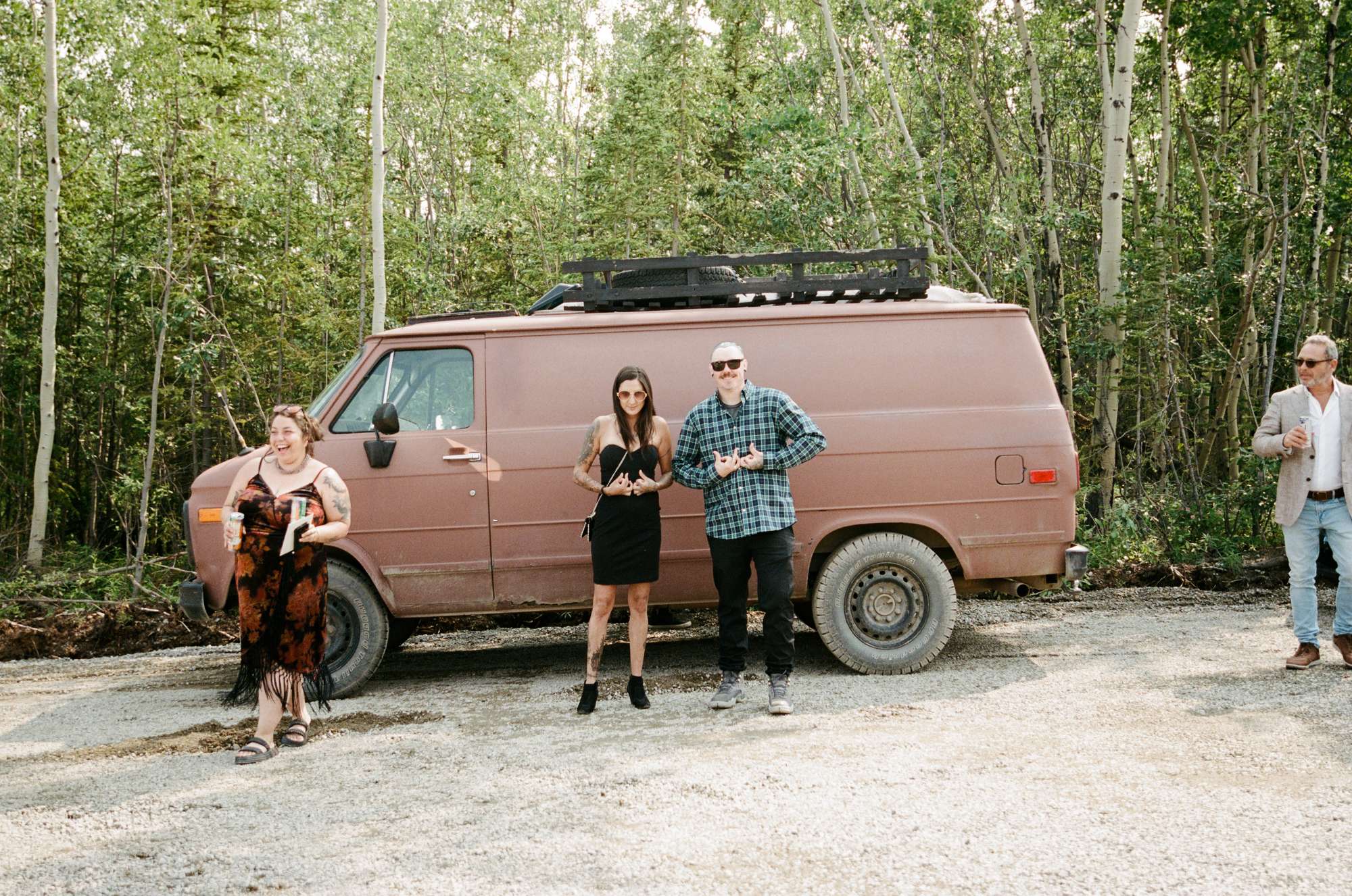 Vintage brown van parked in the boreal forest at a mountaintop wedding