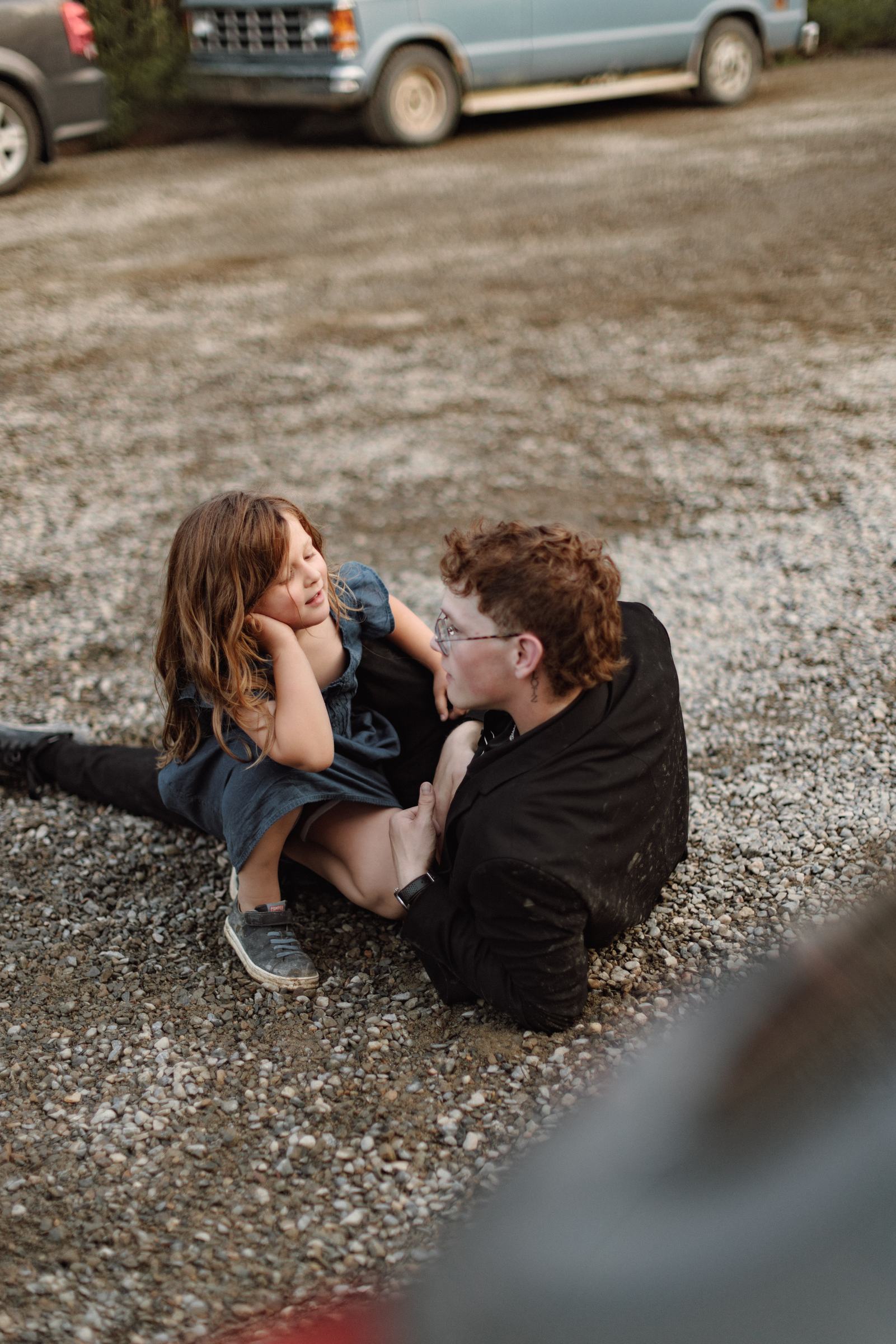Two children lying on the gravel laughing during the wedding party