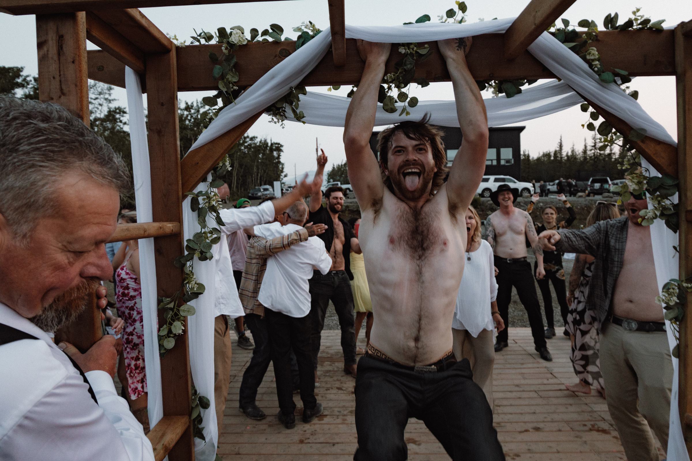 Guest lifting the ceremony arch overhead during the wedding party