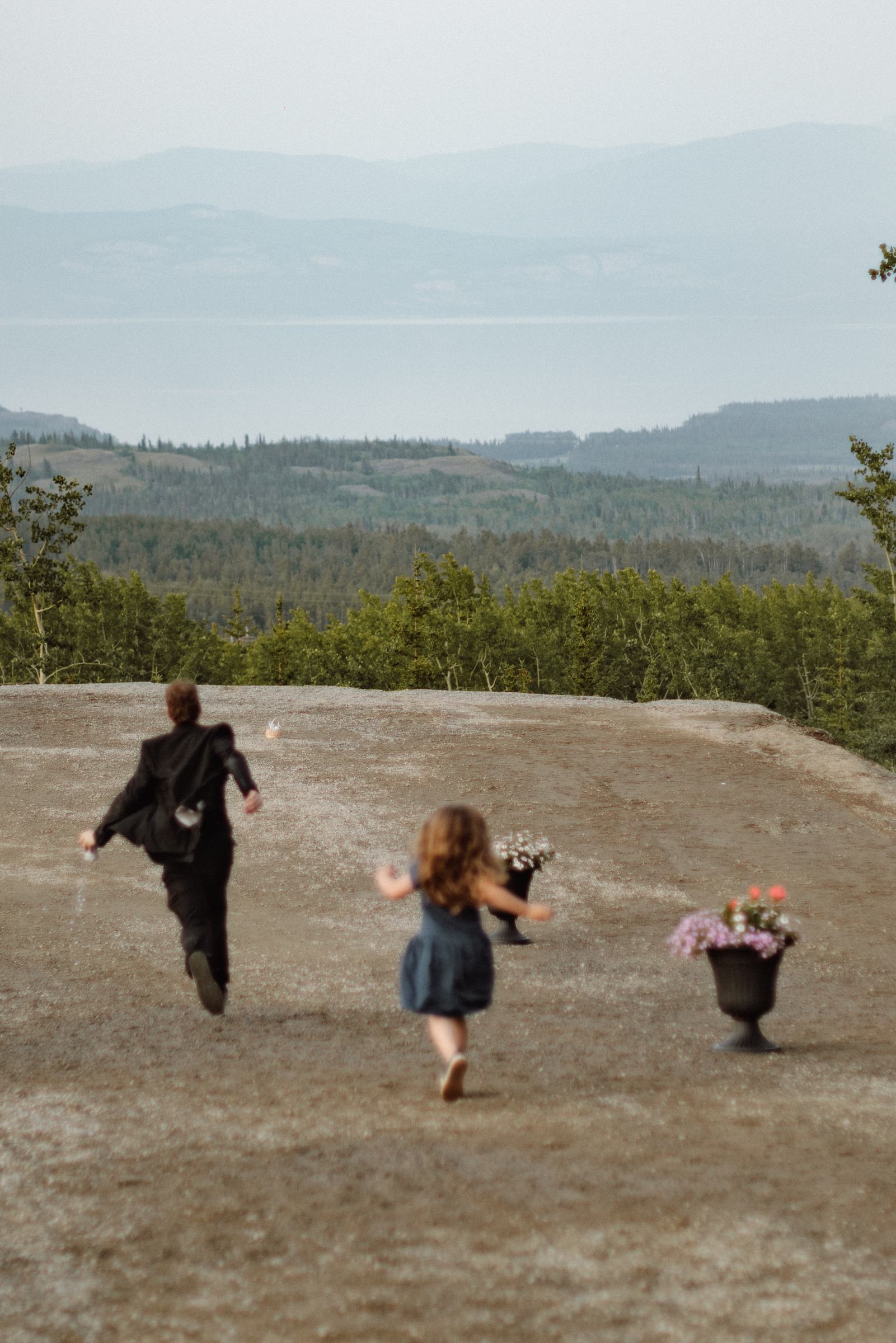 Guest and a small child running on the hillside at dusk