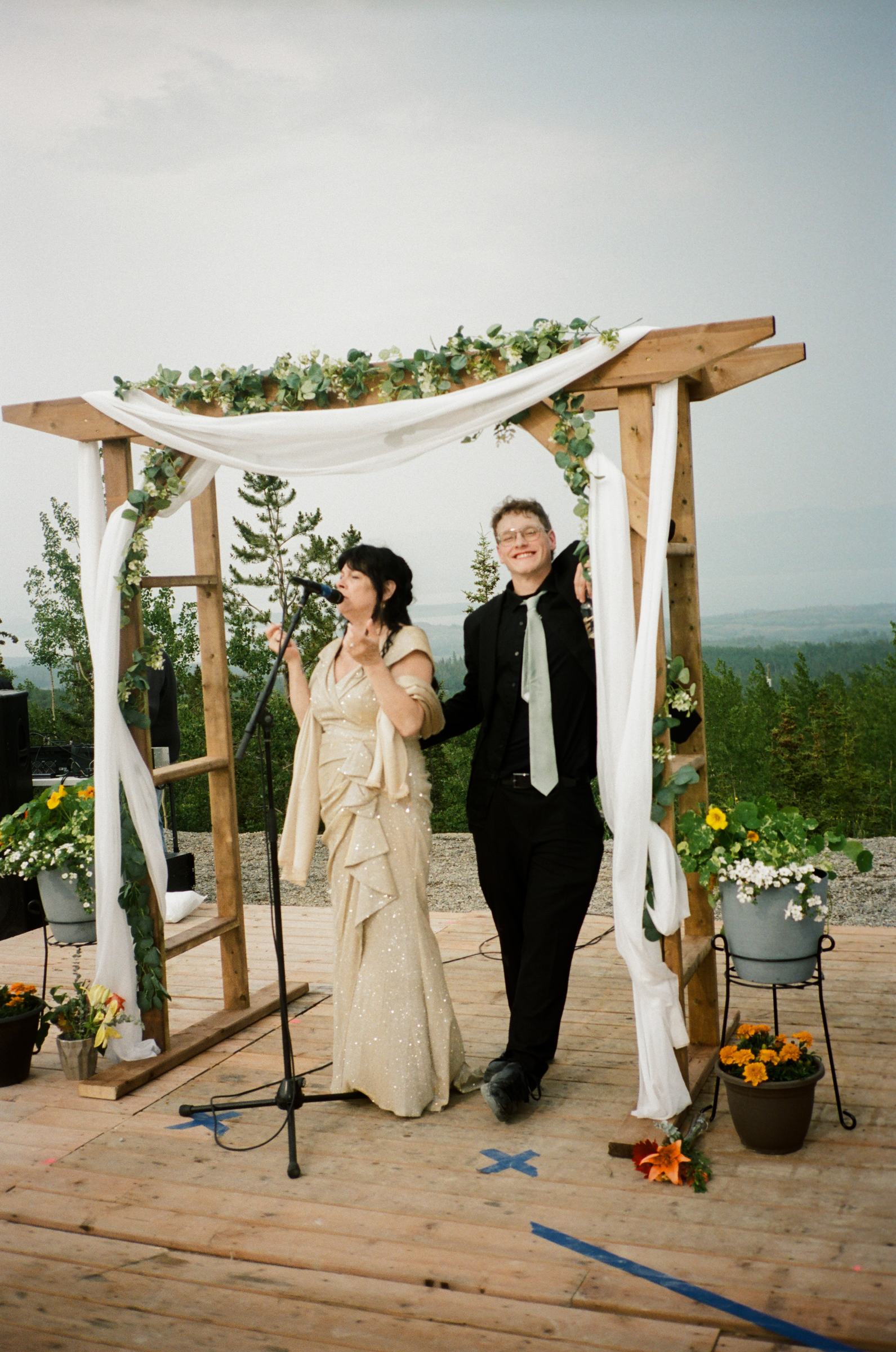 Bride and groom at the ceremony arch photographed on film