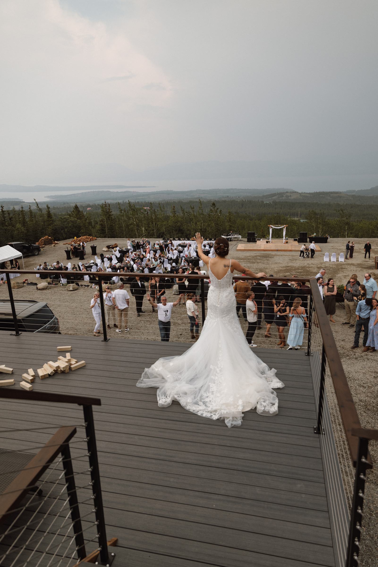 Overhead view of the bride's dress spread across the wooden deck
