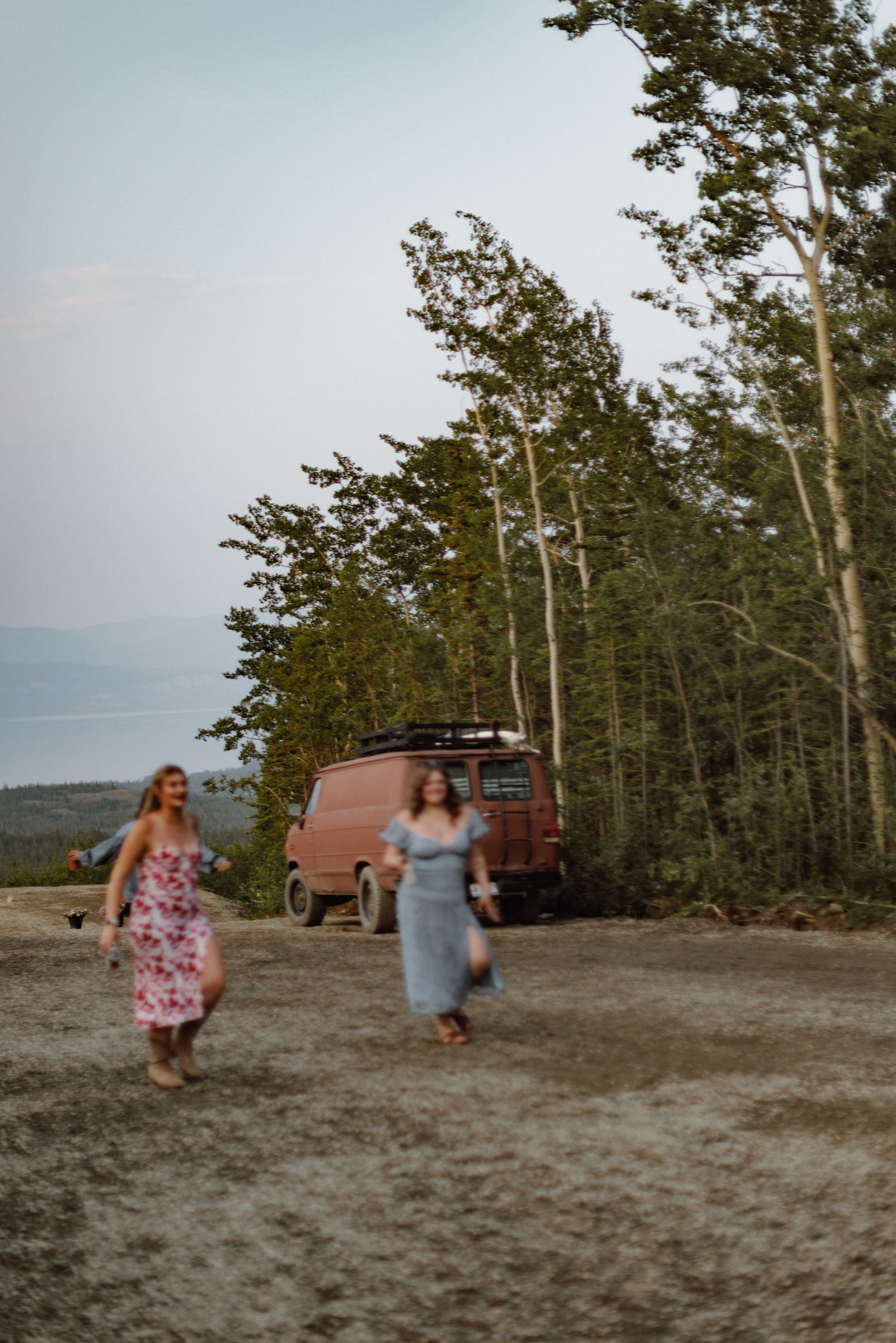 Two guests walking back toward the vintage van at dusk