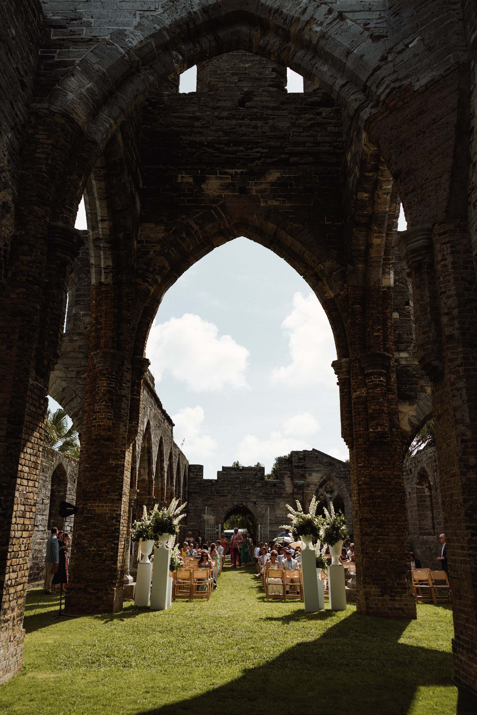 Towering gothic arch of the historic Bermuda church ruins framing the wedding ceremony