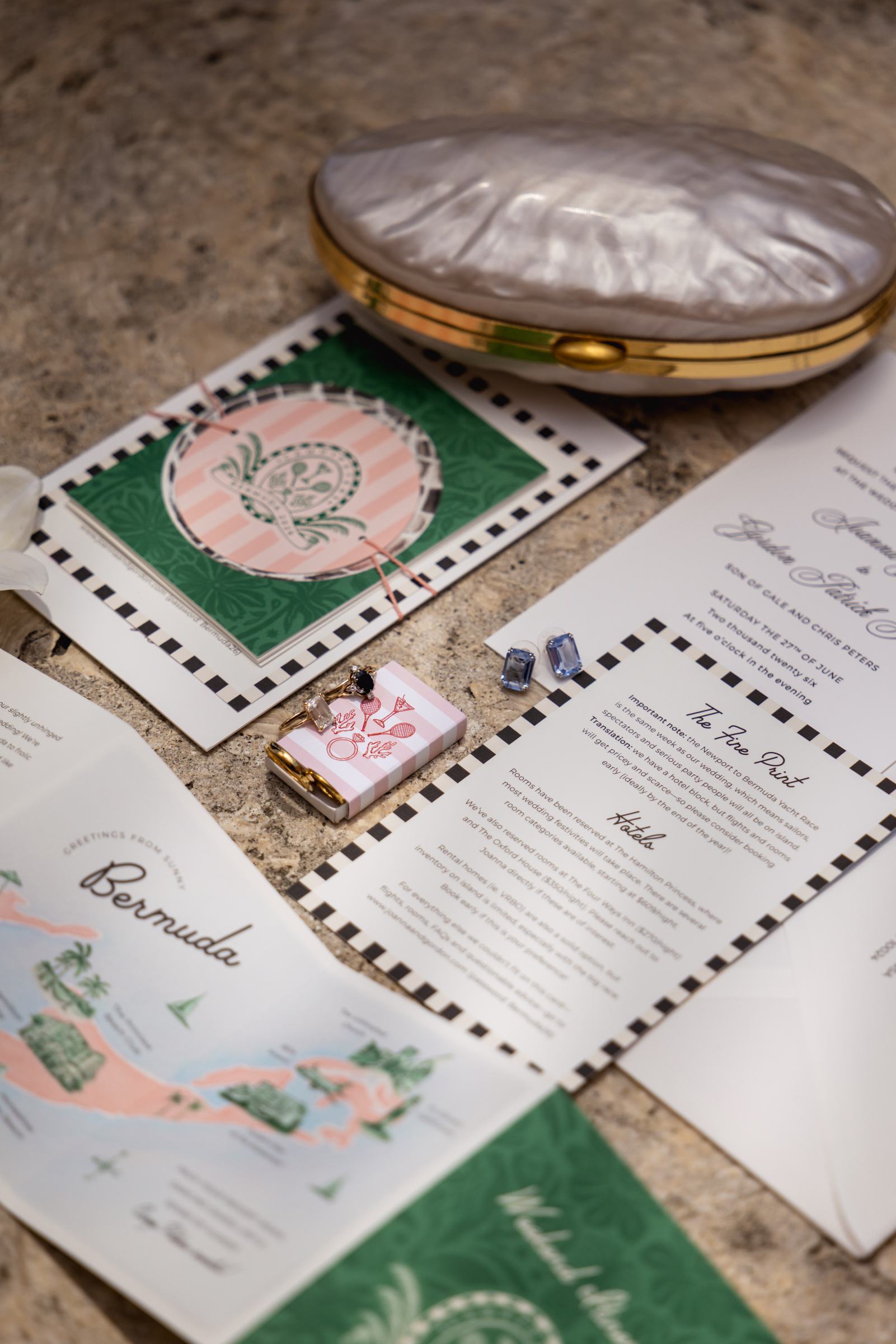Flat lay of the wedding invitation suite with a Bermuda map and a vintage compact
