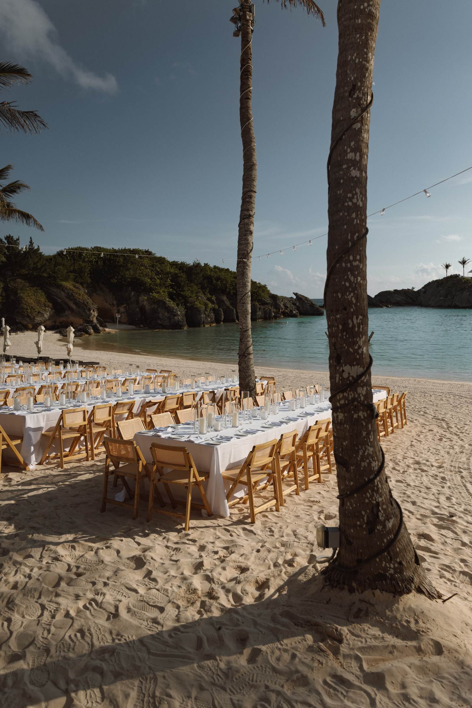 Long welcome party table set under the palm trees on a Bermuda beach
