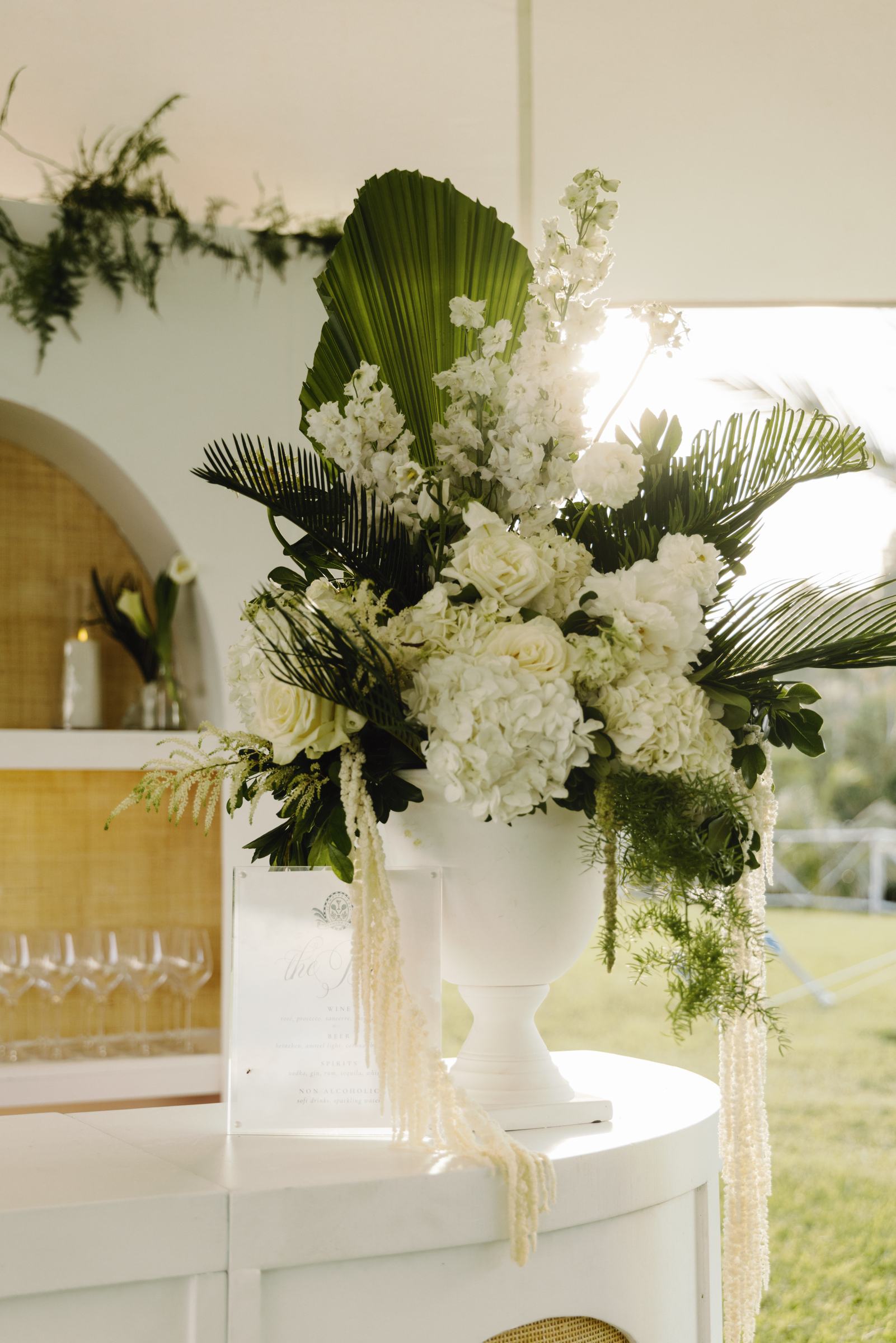 Reception bar dressed with white hydrangea and palm fronds