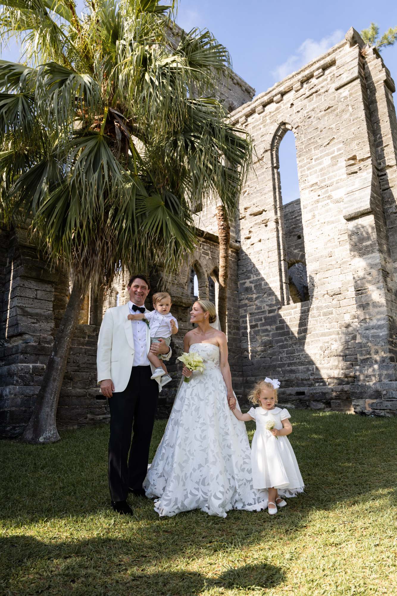 Family portrait inside the Bermuda church ruins with palm trees behind