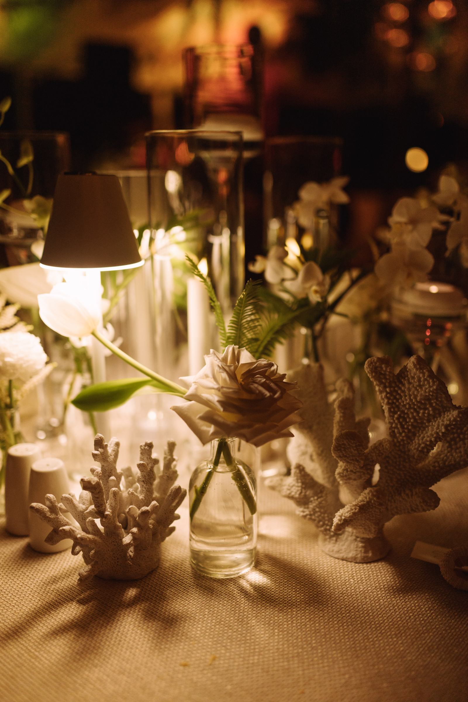 Candlelight, coral and lily centrepieces on a Bermuda wedding reception table