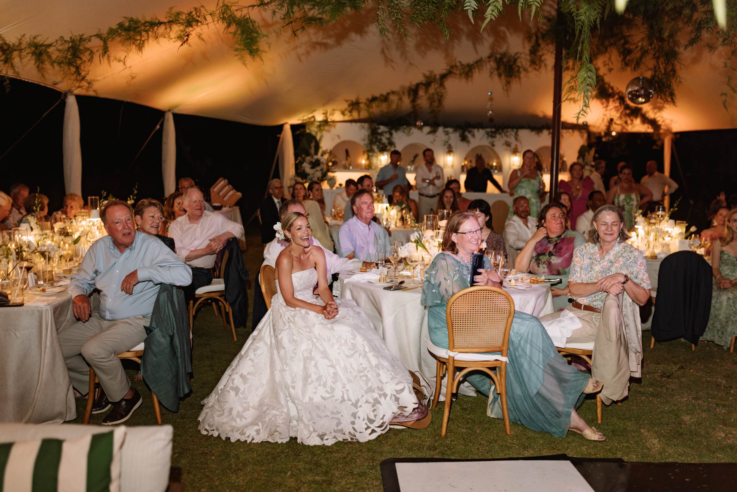 Bride seated among her guests during the speeches at a Bermuda wedding