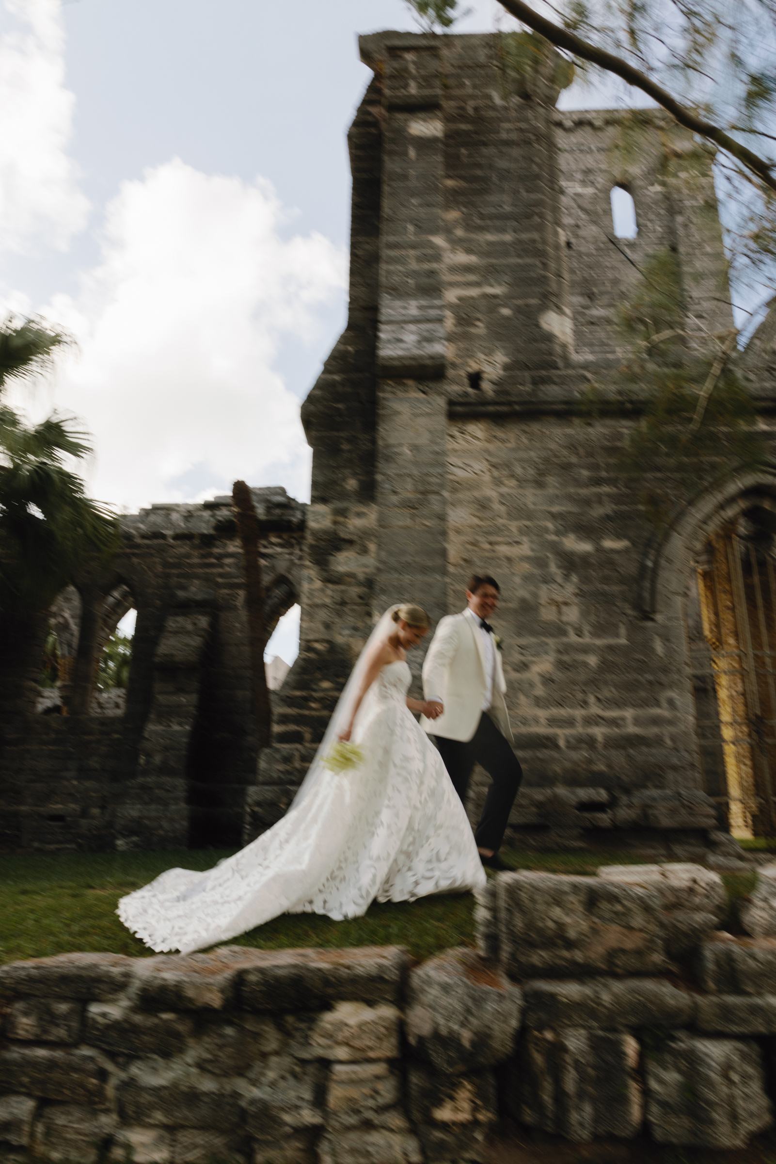 Bride and groom on the steps of the Bermuda church ruins with her train spilling down