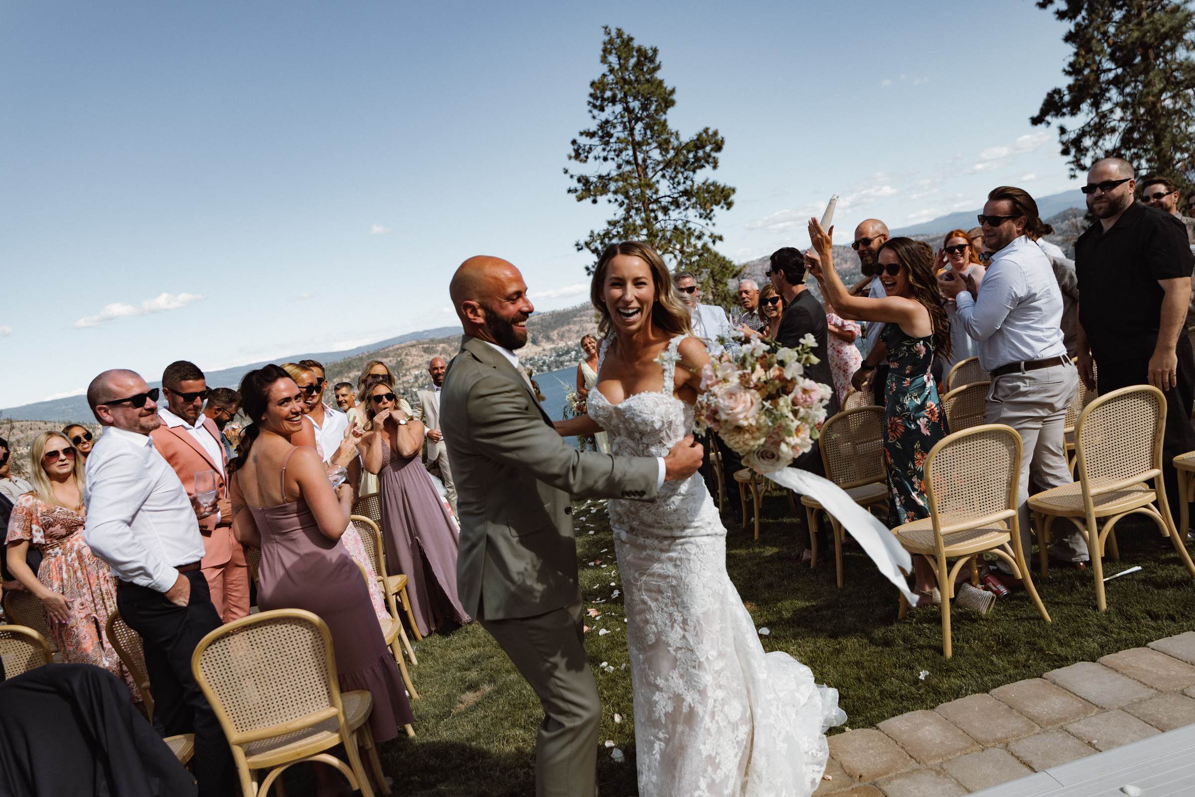 Bride and groom walking the recessional through cheering guests
