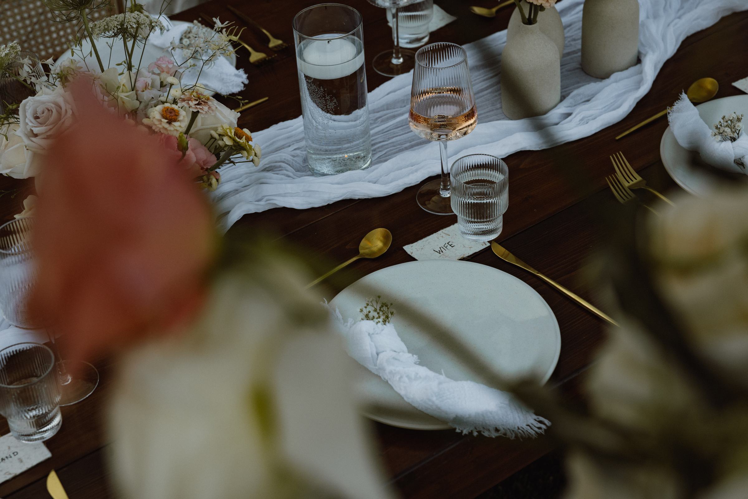 Reception tablescape seen through soft focus flowers
