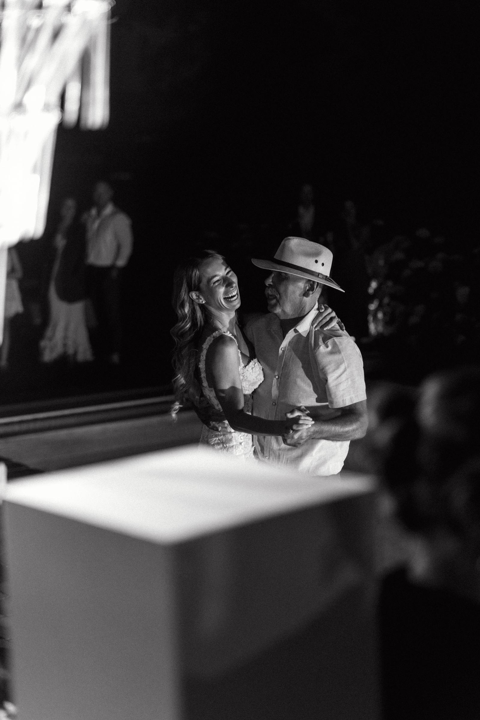 Black and white photograph of the bride and groom laughing close together