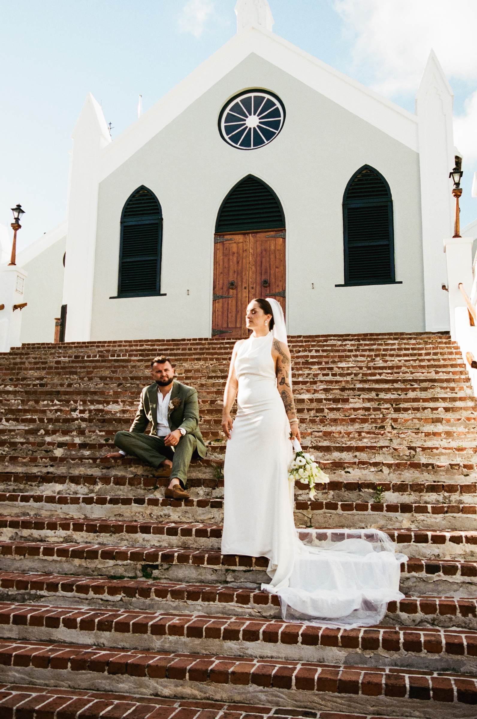 Bride on the brick church steps with her train falling behind her