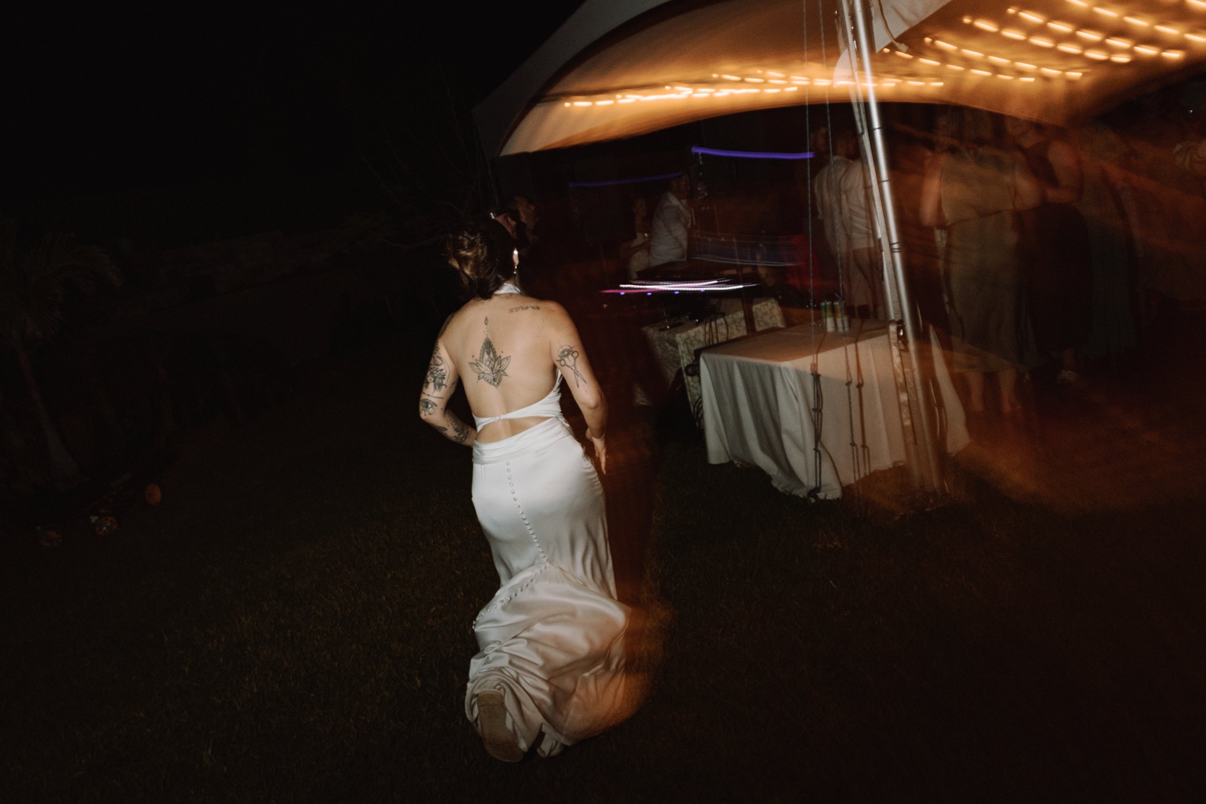 Bride walking away into the night with her dress blurred by movement
