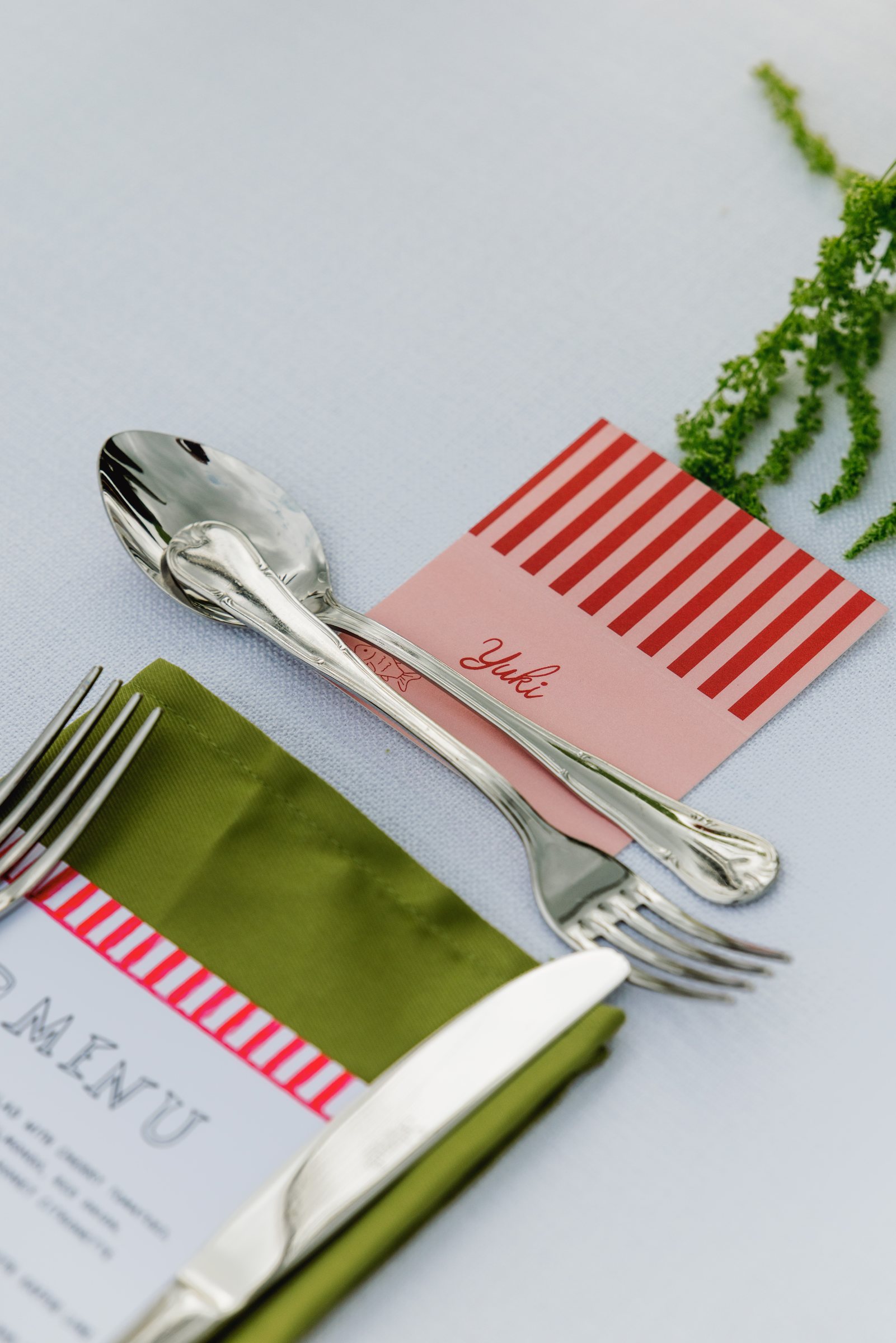 Menu, green napkin and cutlery detail at a Bermuda wedding reception