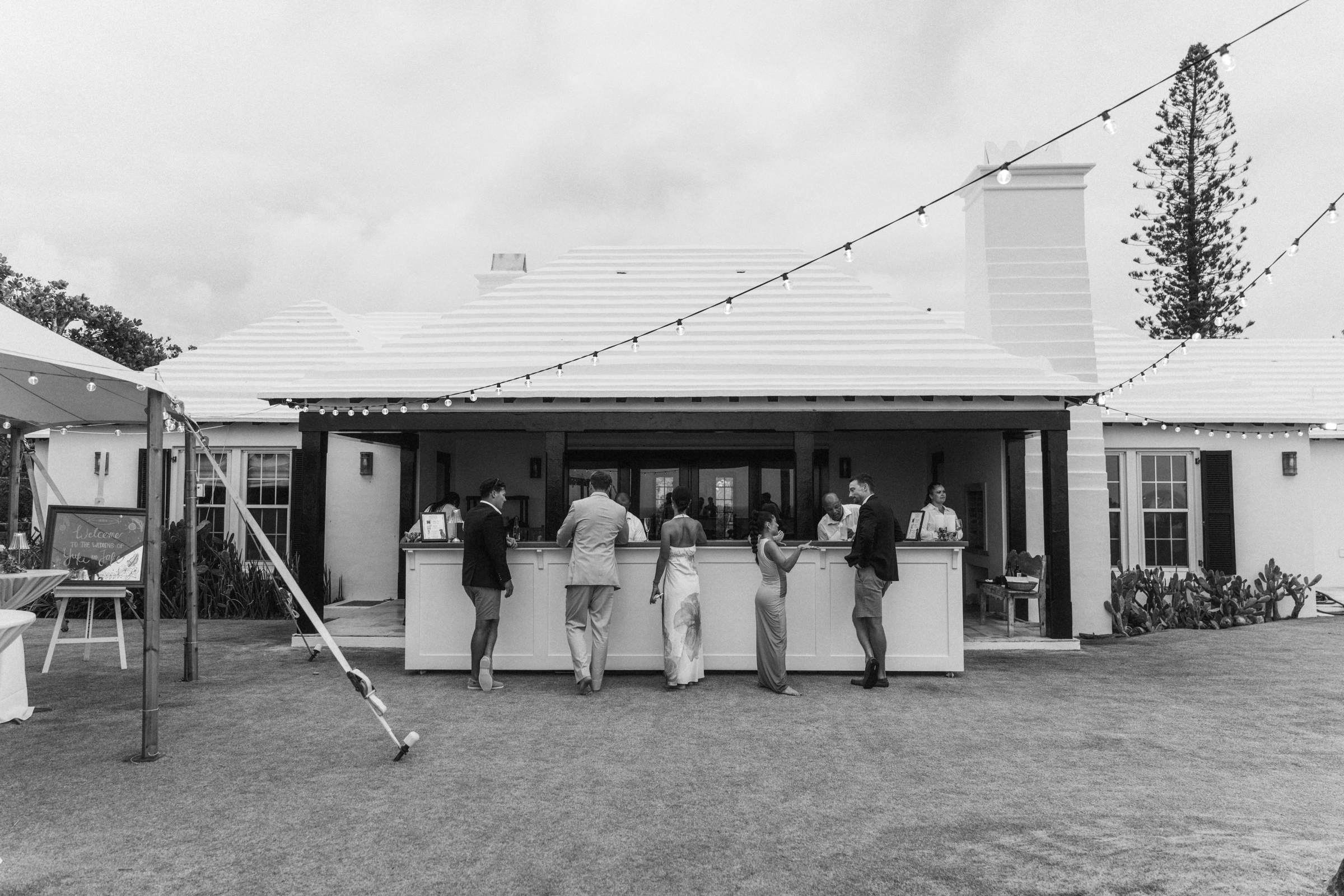 Black and white photograph of the Bermuda house and bar being set up for the reception
