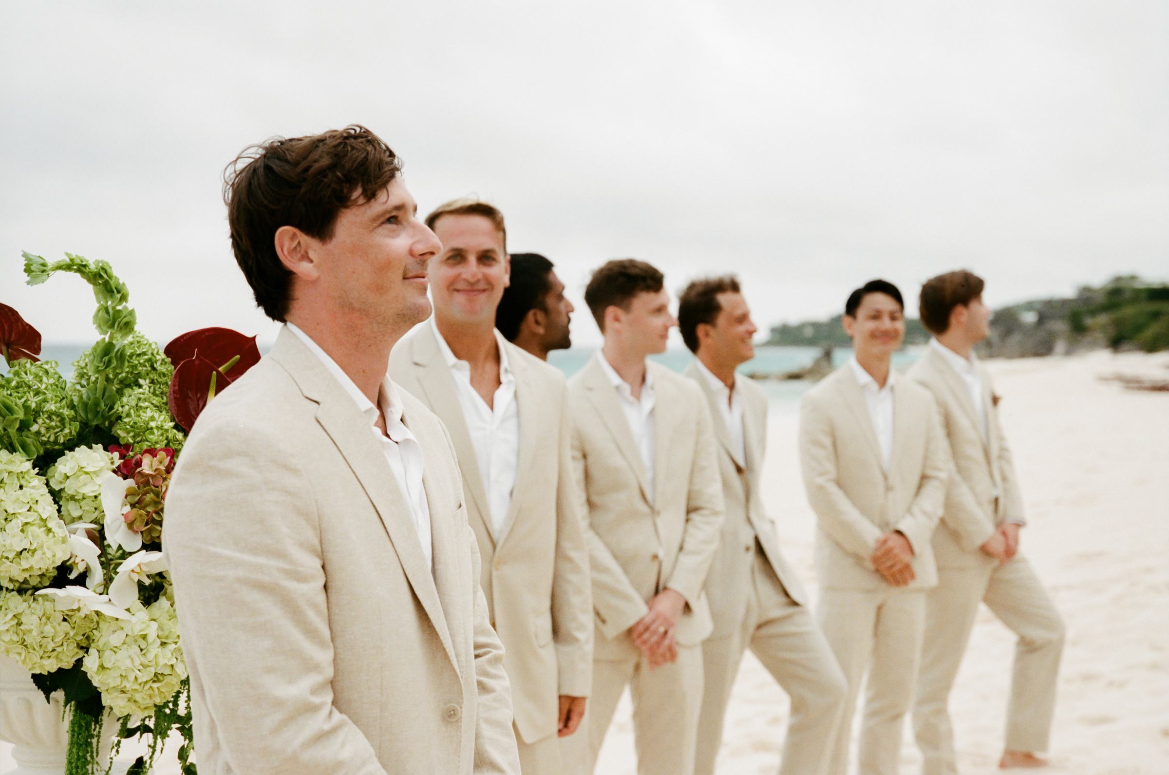 Groomsmen in cream suits walking the Bermuda beach, shot on film