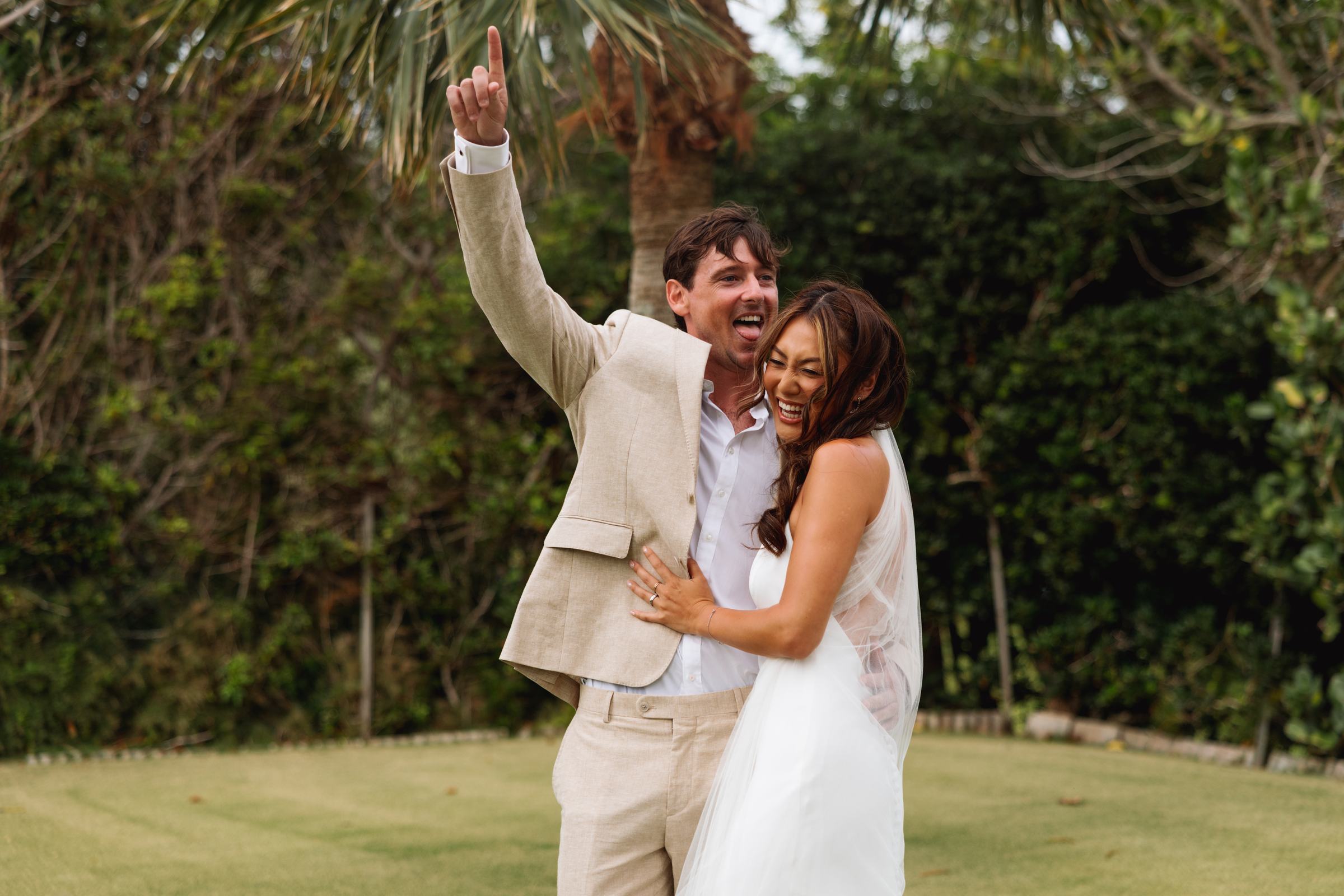 Bride and groom celebrating with an arm thrown up after their ceremony