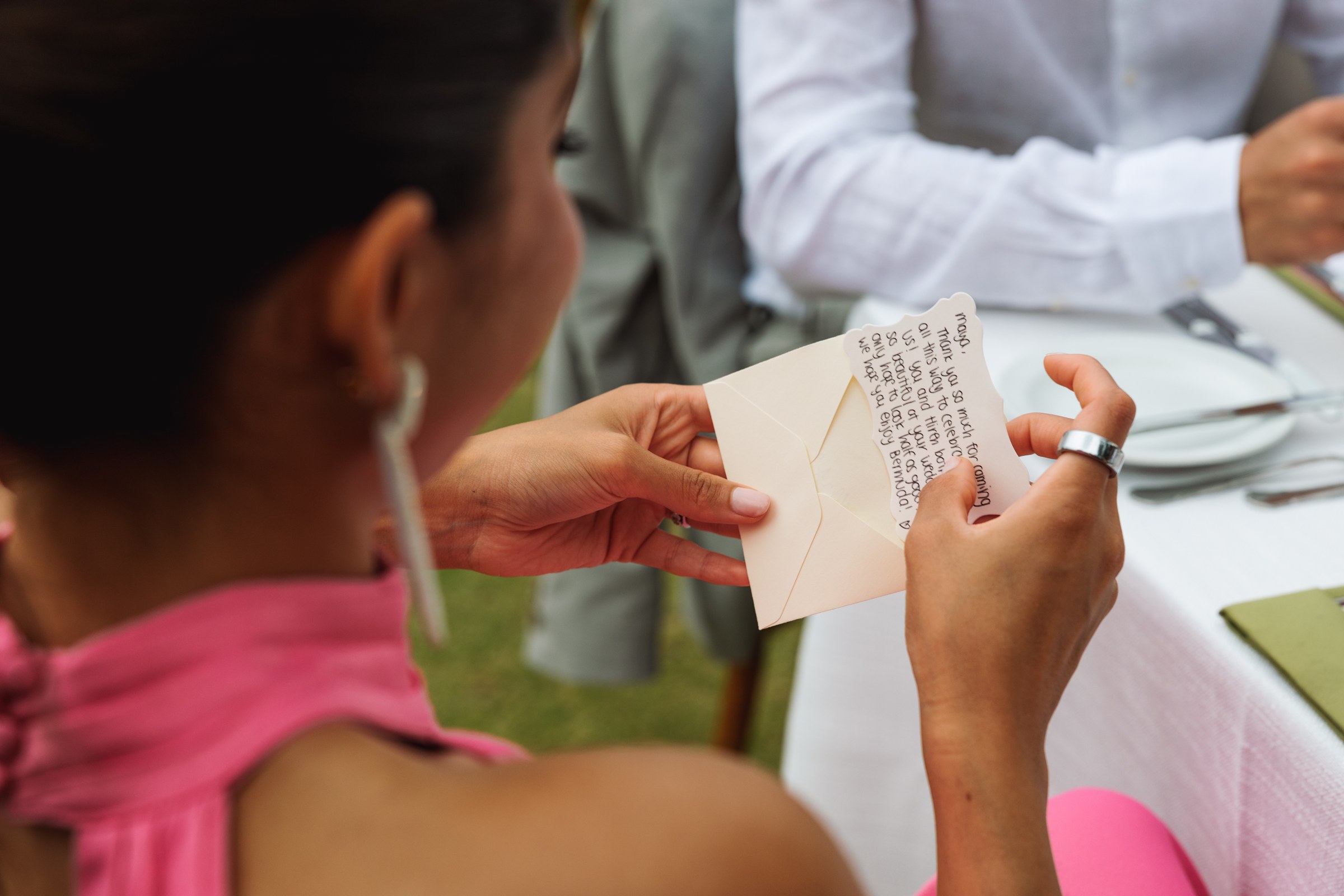 Guest reading a handwritten note at the wedding reception table
