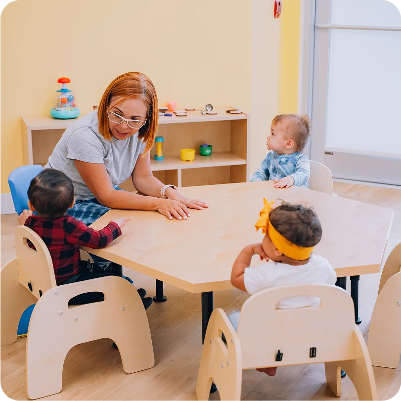 An woman sitting at the table with kids