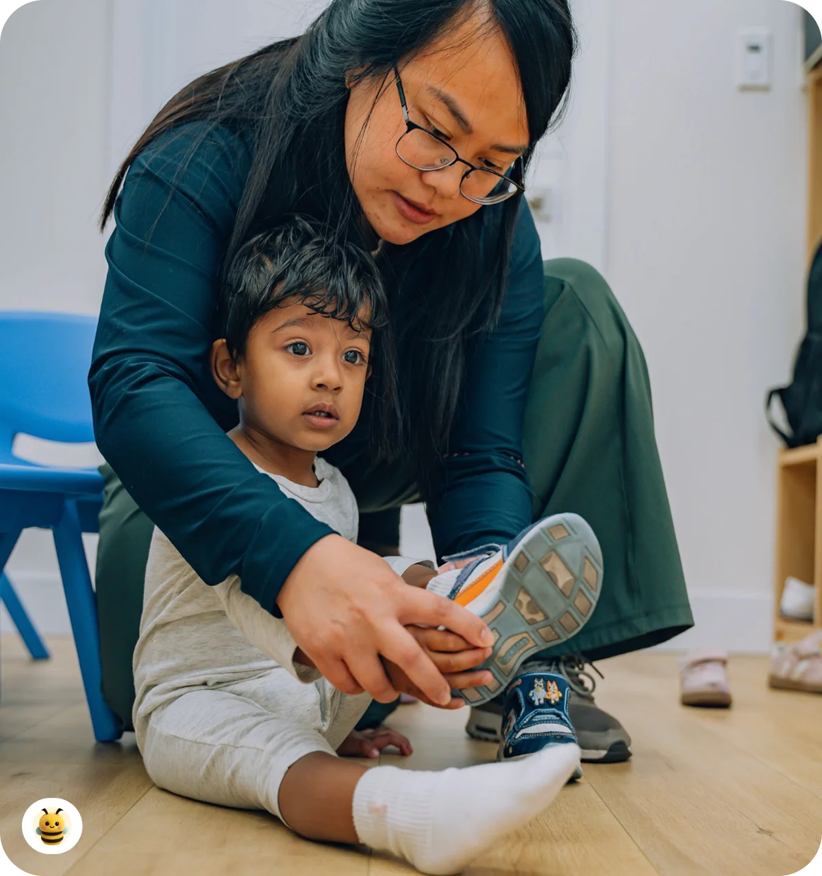 A women help to a boy to take on a shoe