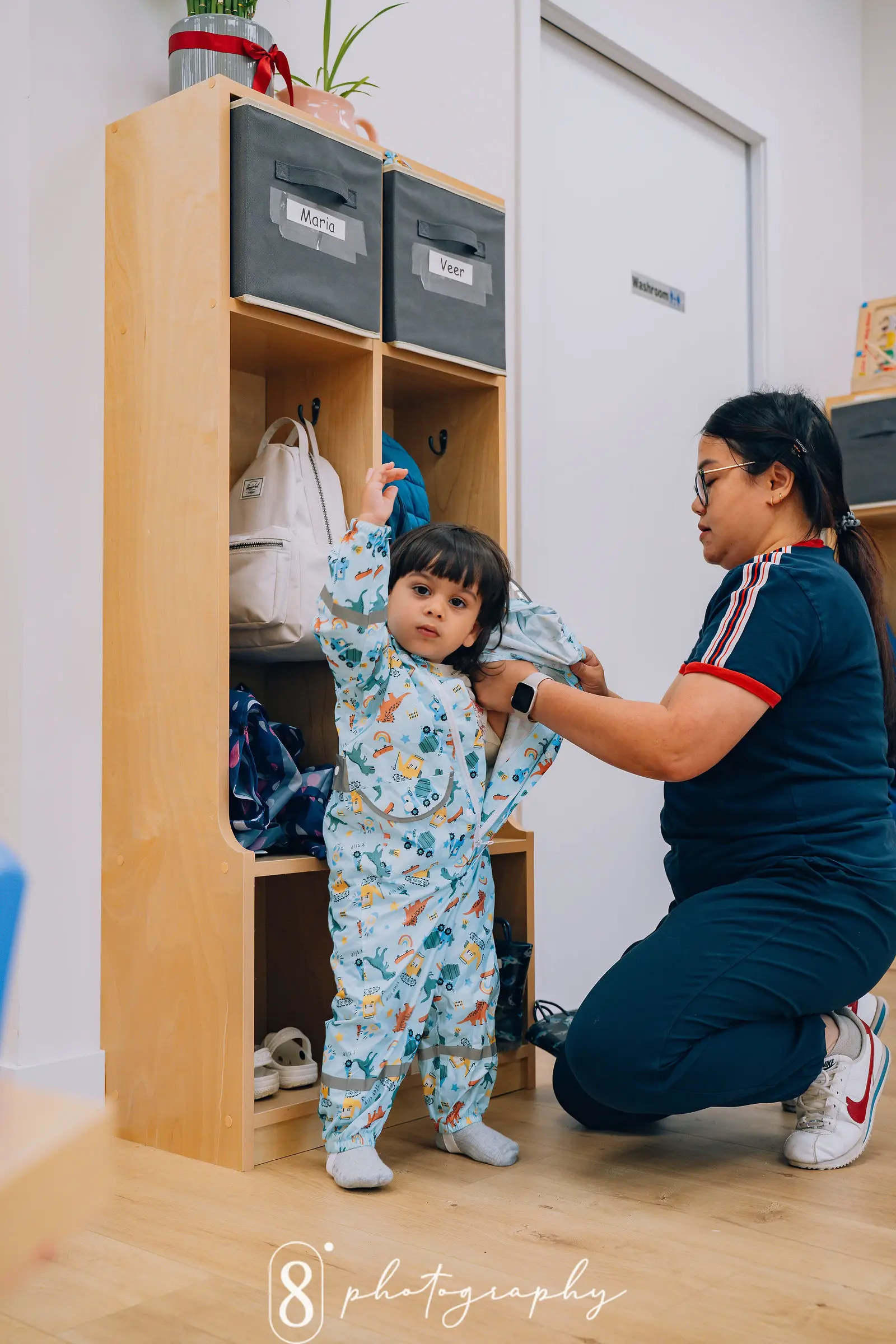 A woman helps kid to put on a jacket