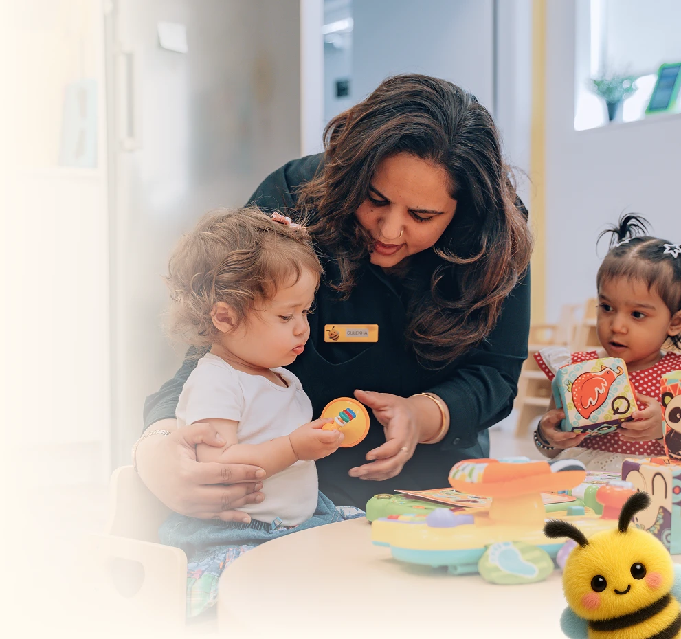 B Kids educator playing with toddlers in a bright classroom
