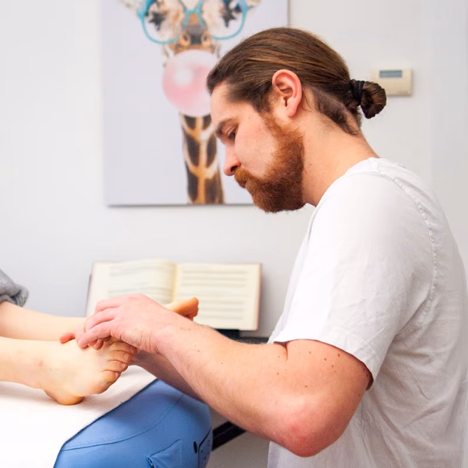 Der Heilmasseur Markus Anderle massiert Füße einer entspannten Kundin in Linz