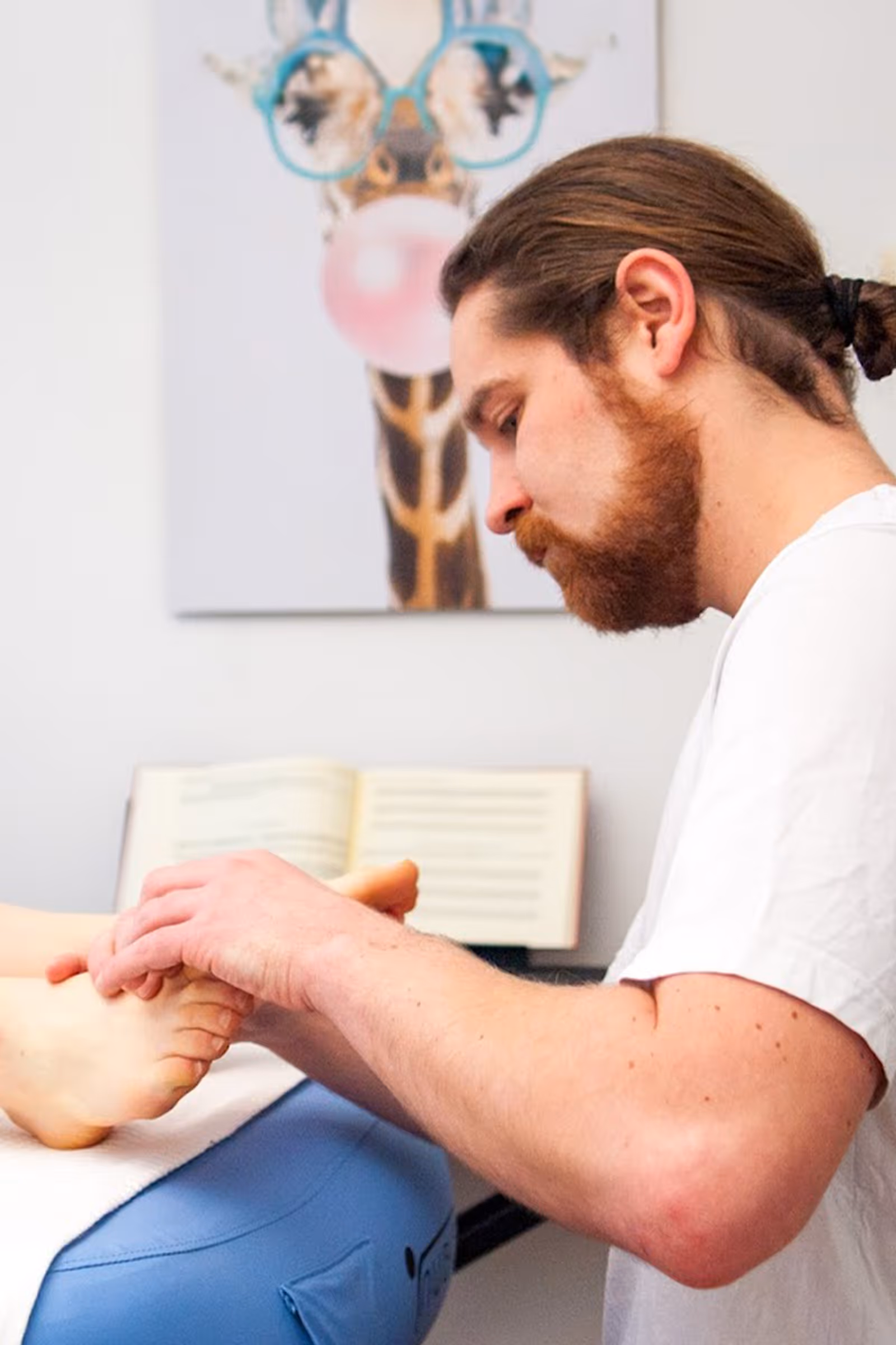 Der Heilmasseur Markus Anderle massiert Füße einer entspannten Kundin in Linz