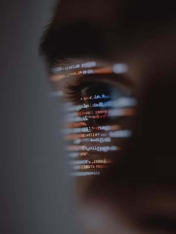 Närbild av ett öga med kodreflektioner reflekterade över ögonlocket och runt ögat.