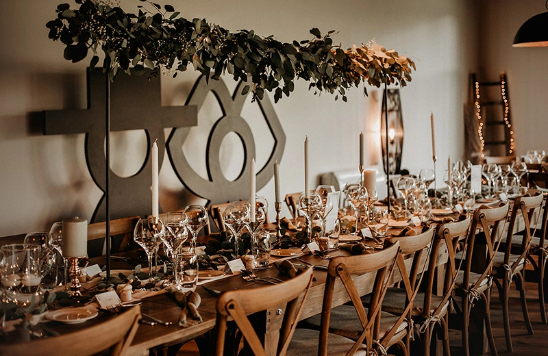 Table de mariage élégamment décorée avec des fleurs et des verres à pied à La Ferme Marie Hélène.