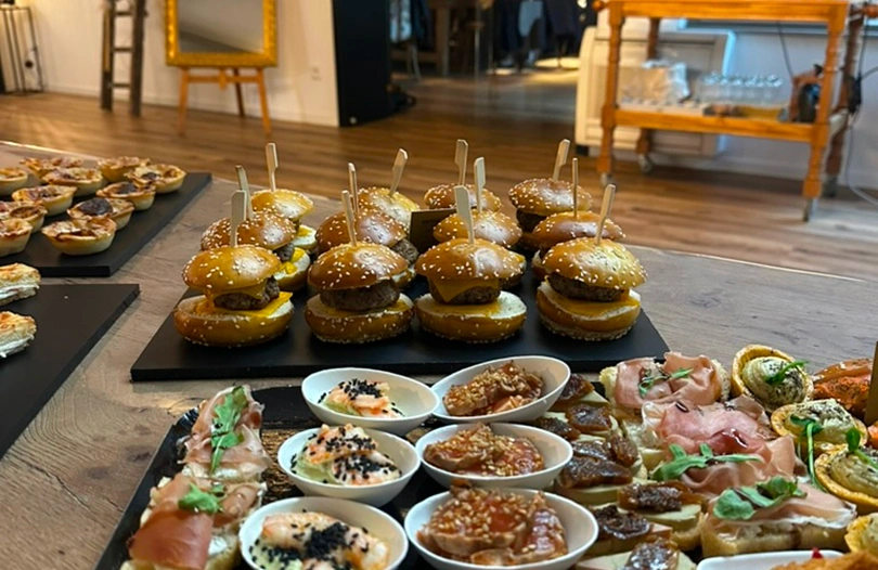 Plateau de bouchées apéritives avec mini-burgers et verrines, préparé pour un événement à La Ferme Marie Hélène.